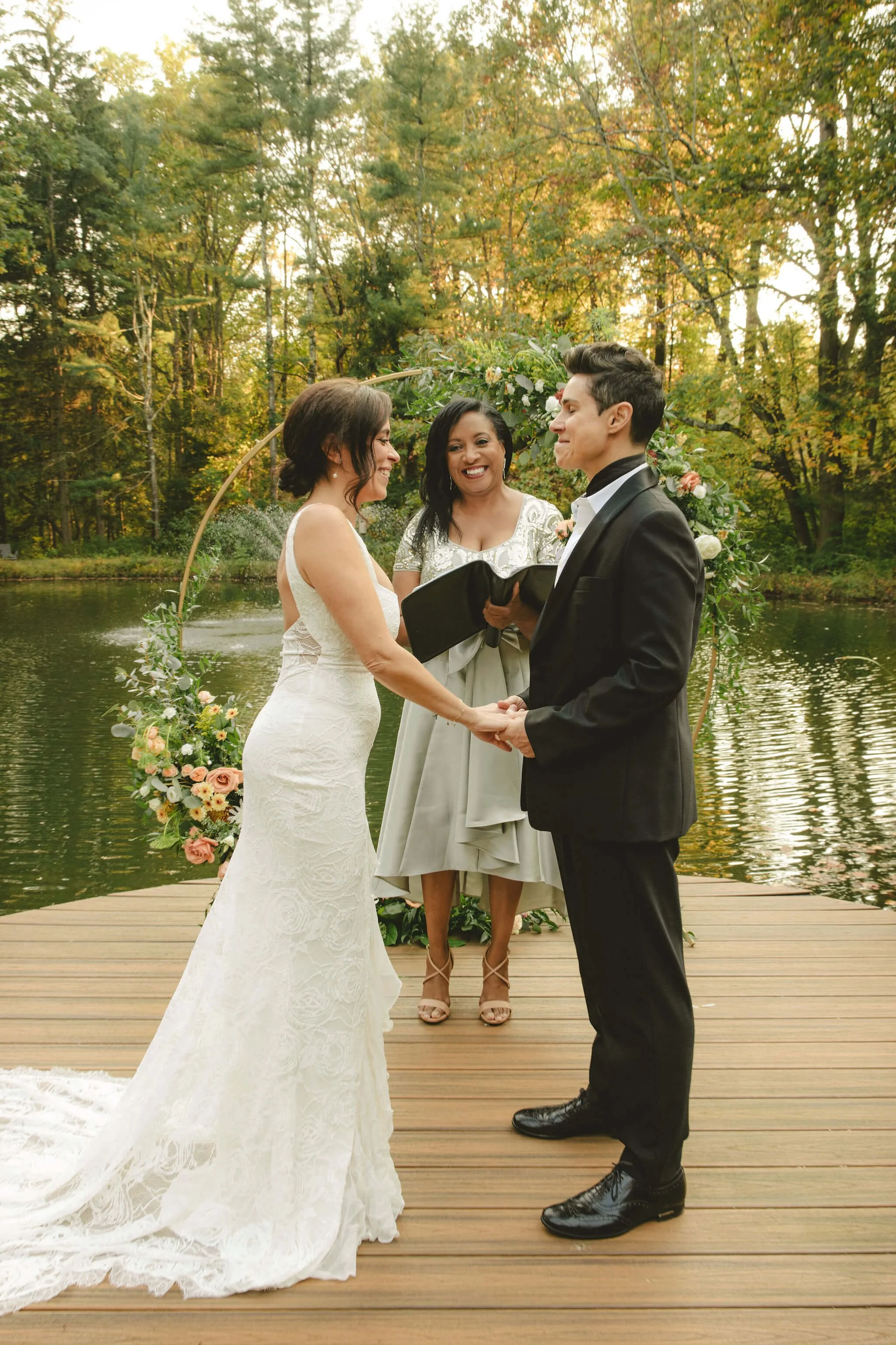 Officiant standing with a couple during their lakeside elopement ceremony in Barnardsville, New Jersey
