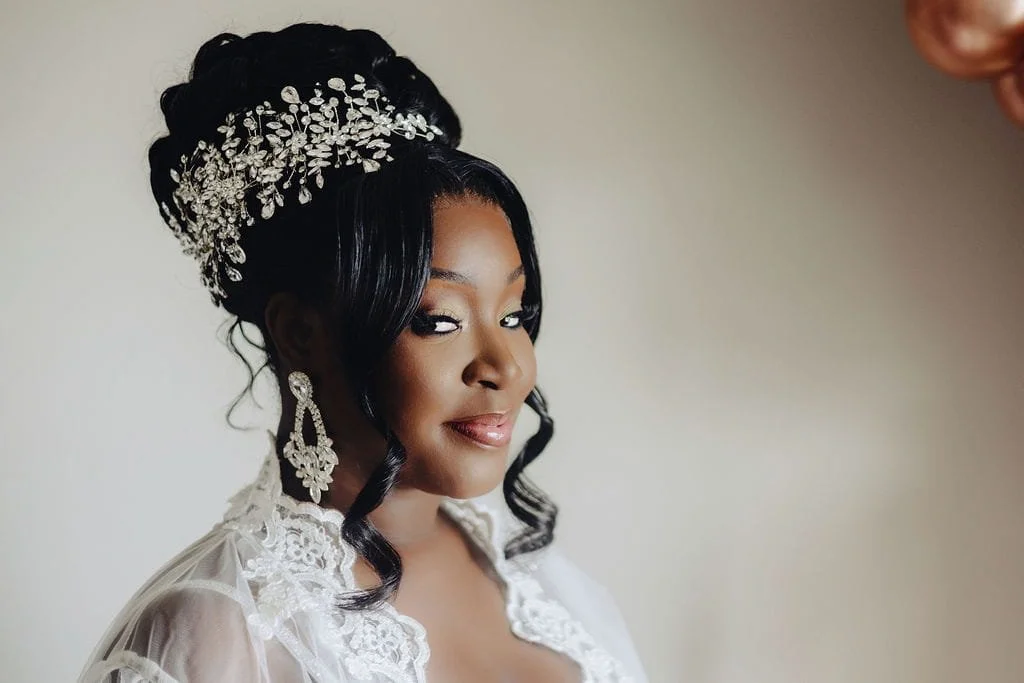 Kristie in her bridal robe with jeweled hairpiece and earrings before her wedding ceremony.