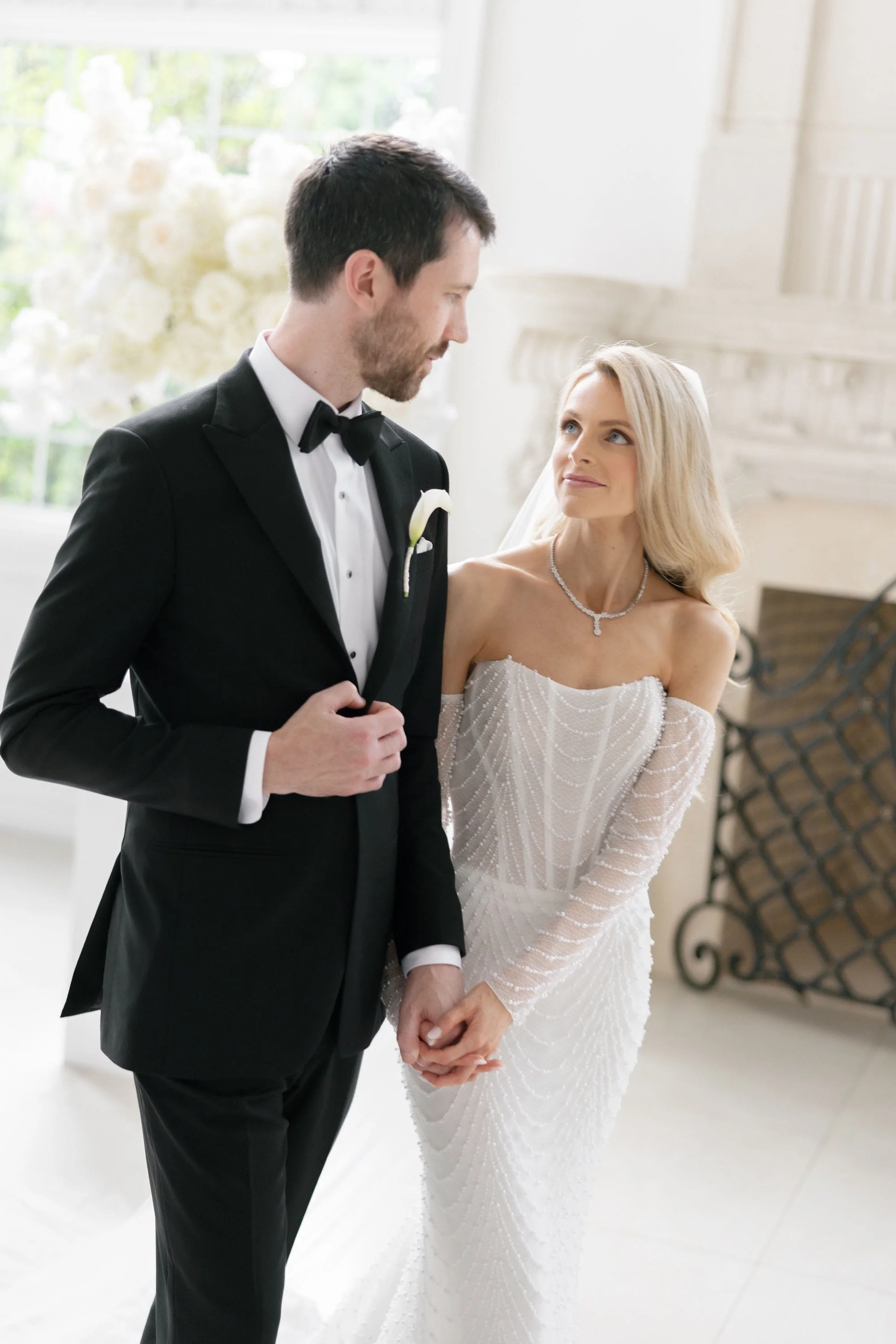 Caroline and Brett holding hands during an indoor wedding portrait at Florentine Gardens in River Vale, NJ