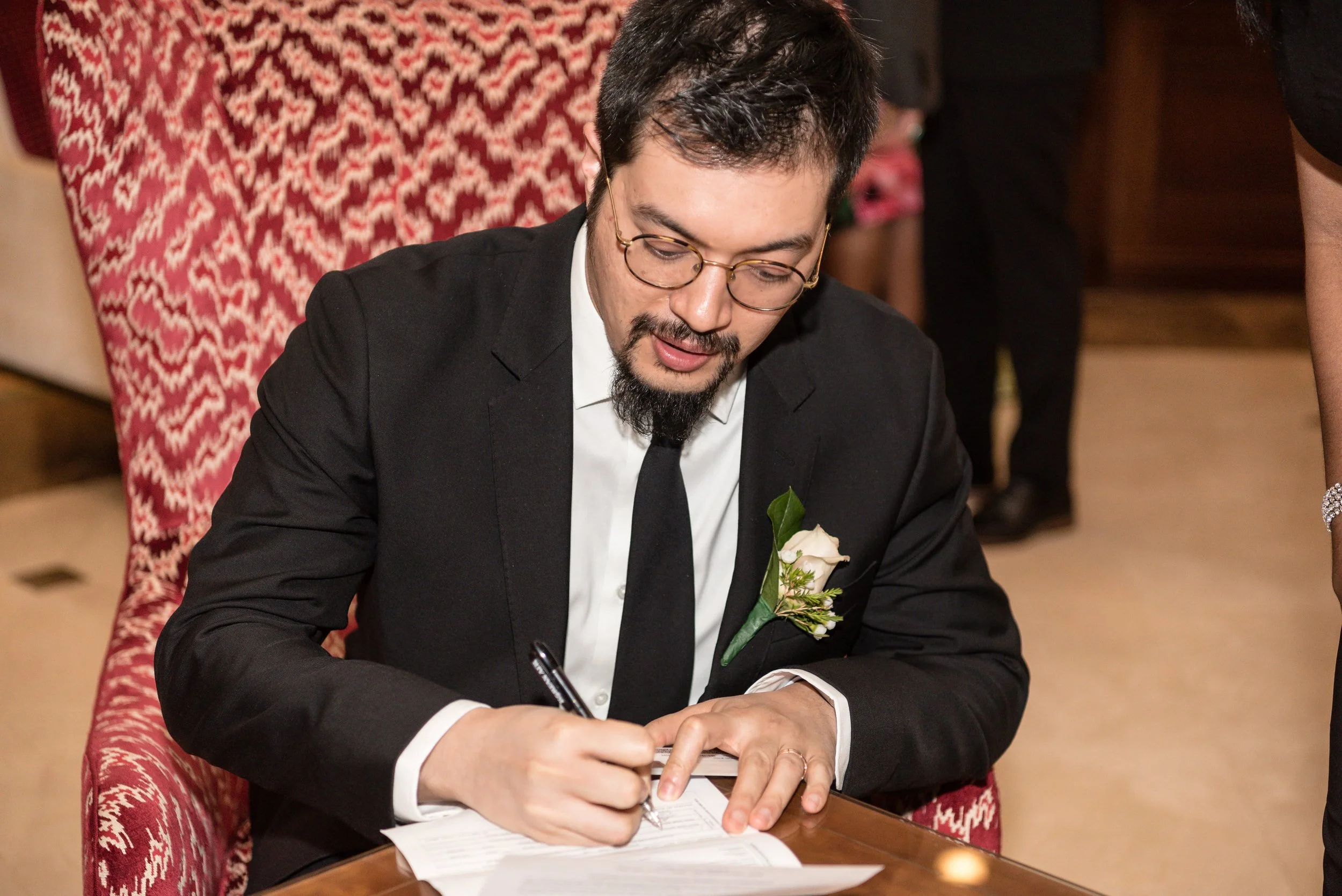 Groom completing marriage paperwork during a New Jersey wedding ceremony.