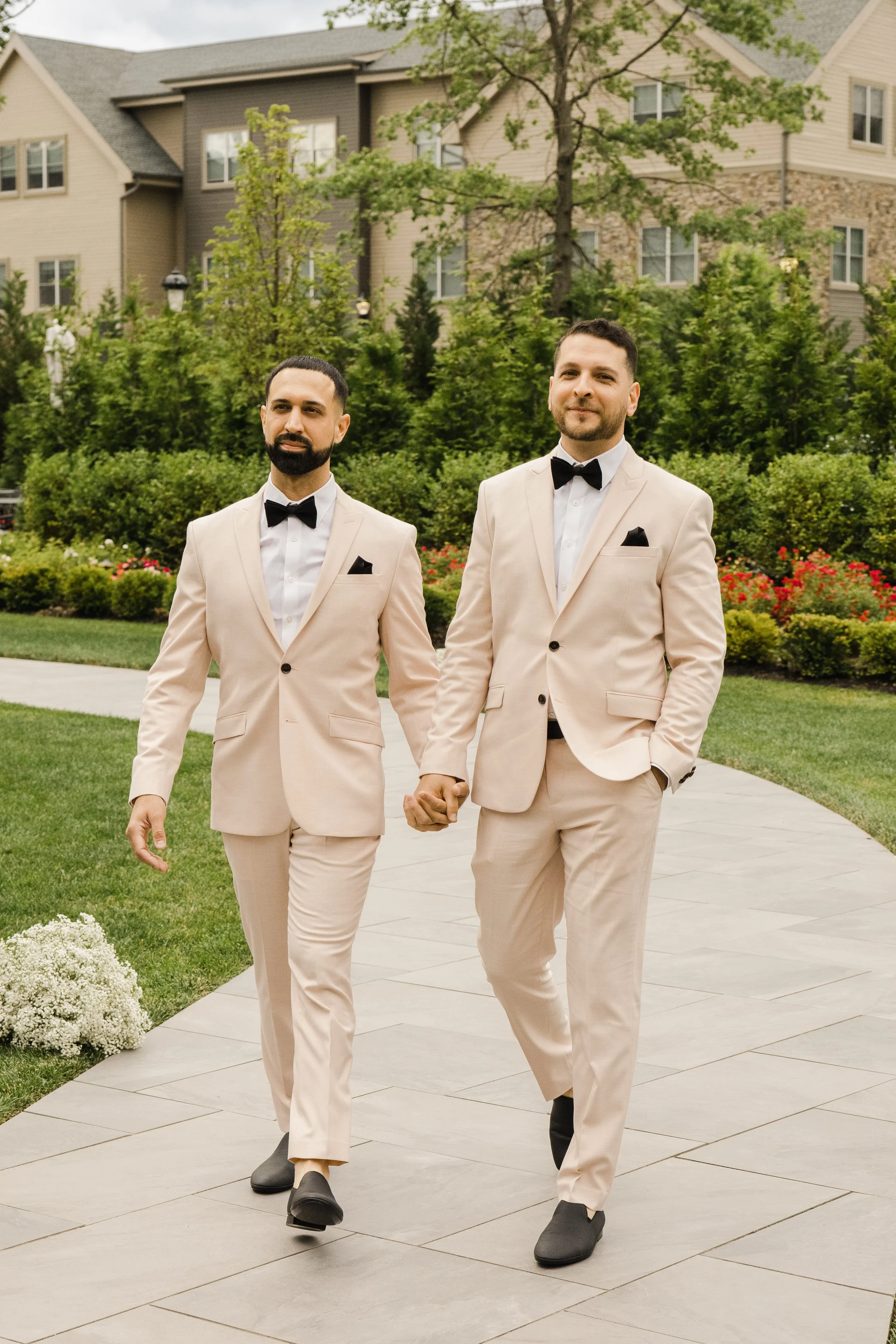 Same-sex newlywed couple holding hands after their luxury elopement at The Château Grande Hotel in East Brunswick, New Jersey.