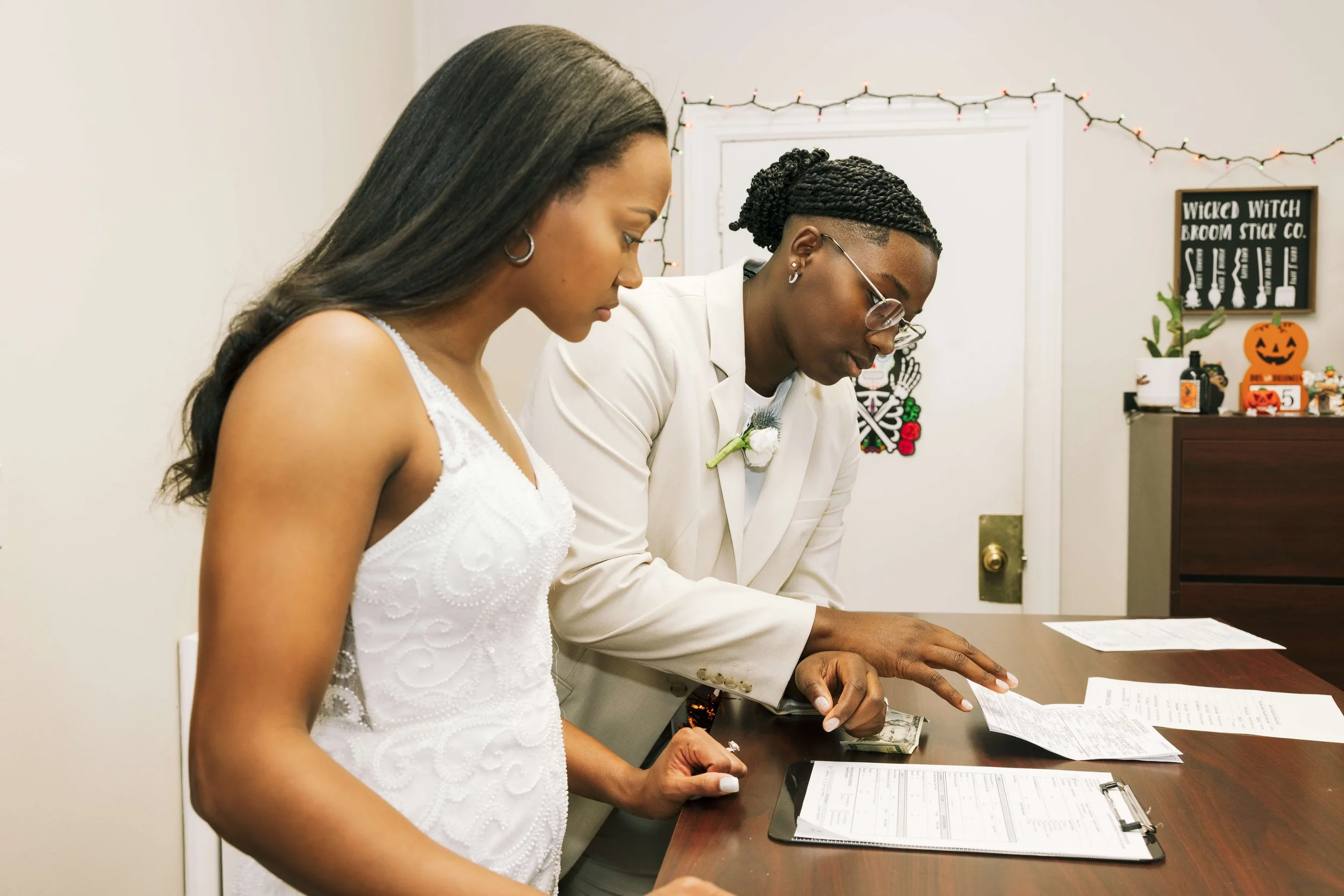 Jaide and Amiaya review paperwork at a New Jersey registrar’s office while obtaining their certified marriage certificate after their wedding.
