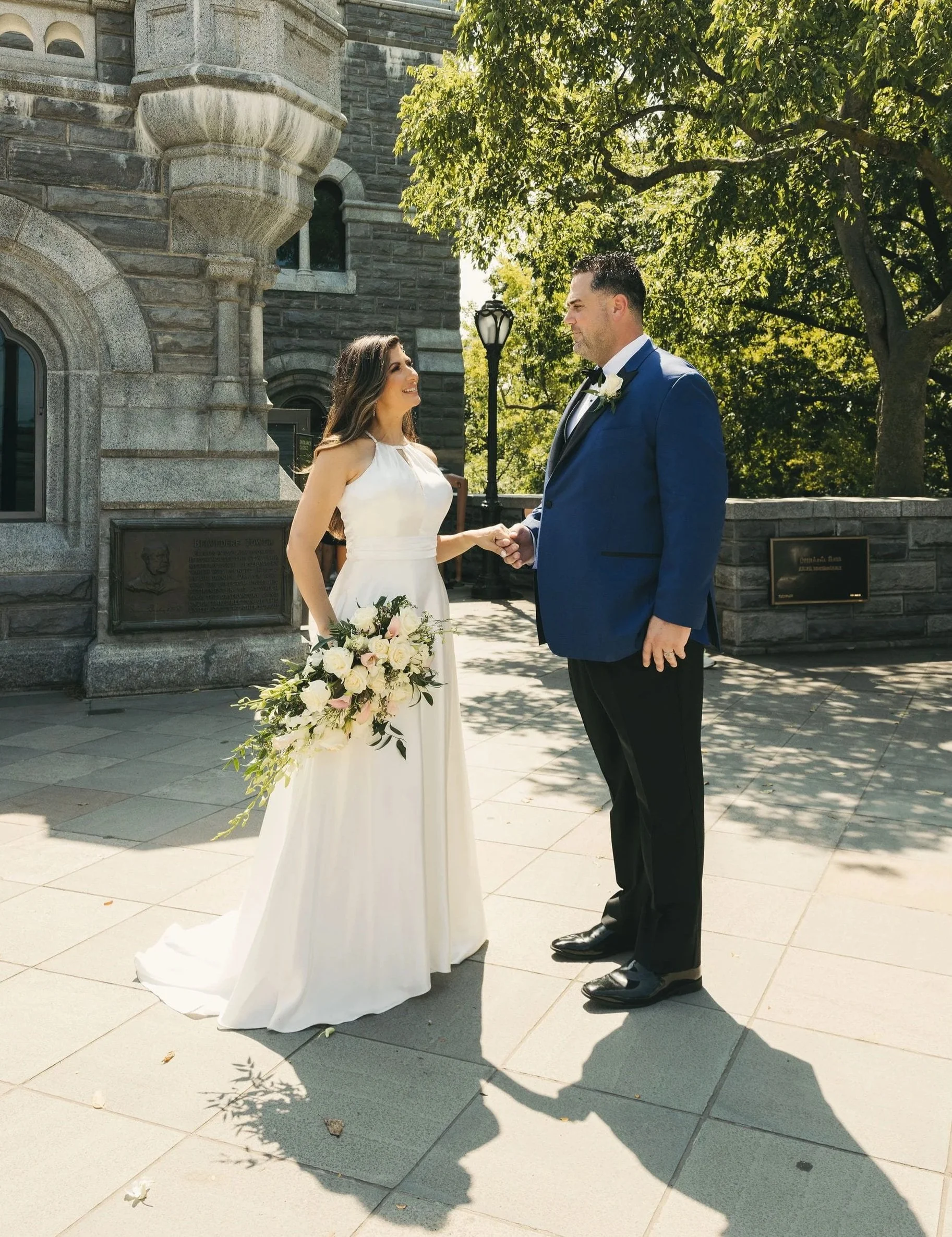 Newlywed couple holding hands outside Belvedere Castle in Central Park after their New York City elopement