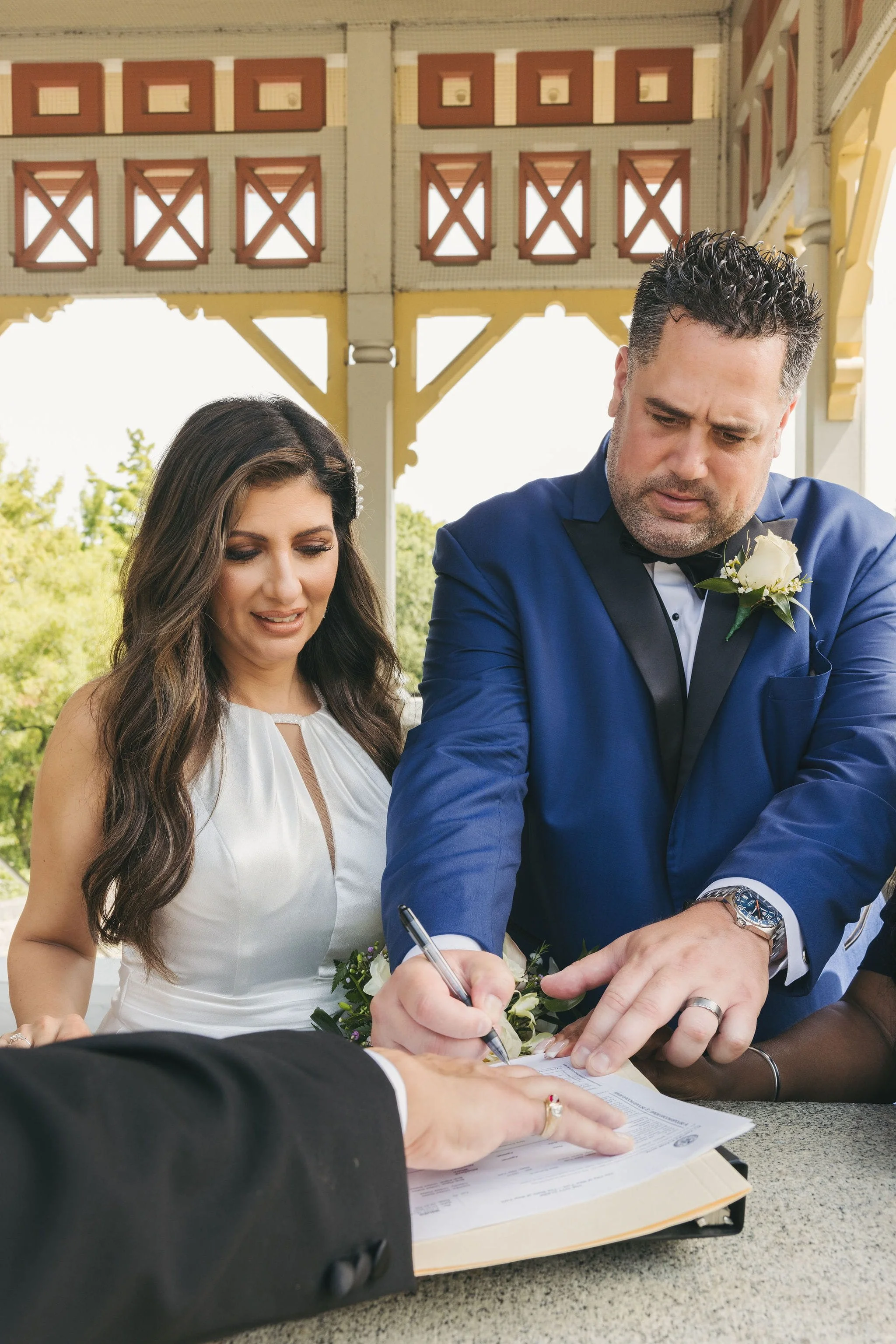 Couple signing their marriage license during an intimate wedding signing at Belvedere Castle in Central Park, New York City.