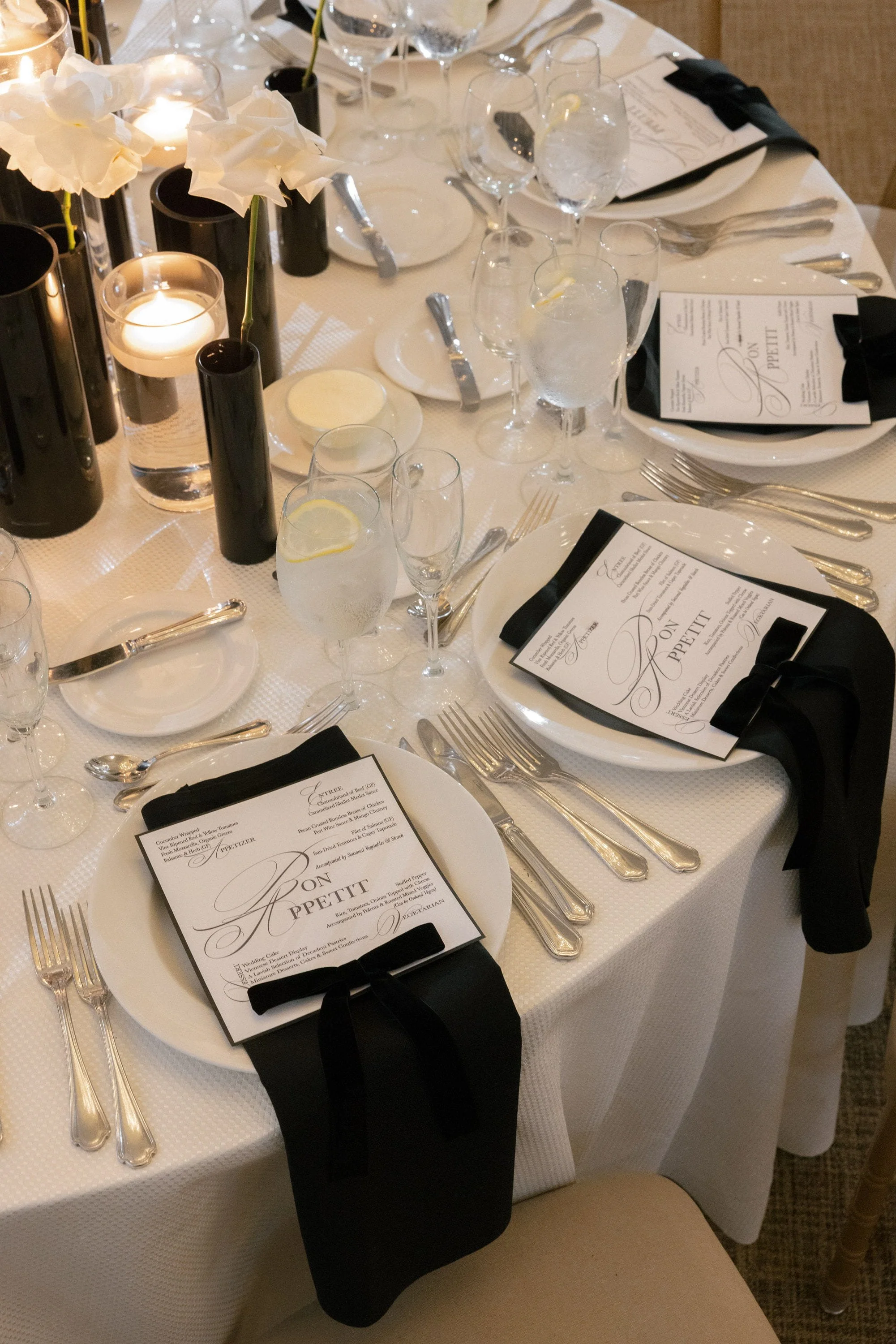 Elegant wedding reception table with white florals, candlelight and gold place settings