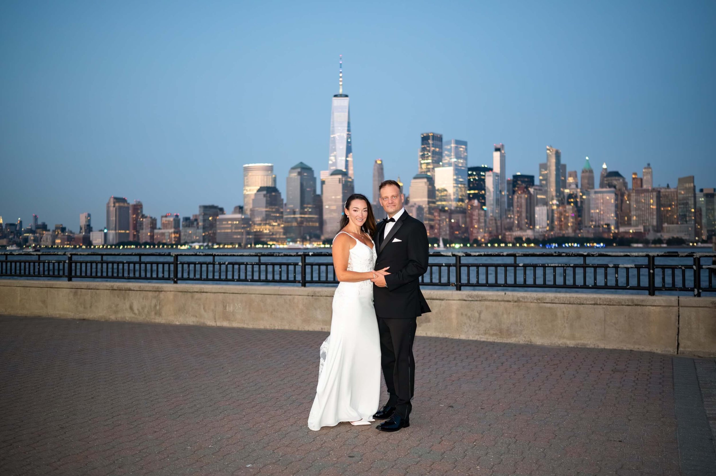 Couple standing together after their elopement at Liberty State Park with the New York City skyline in the background