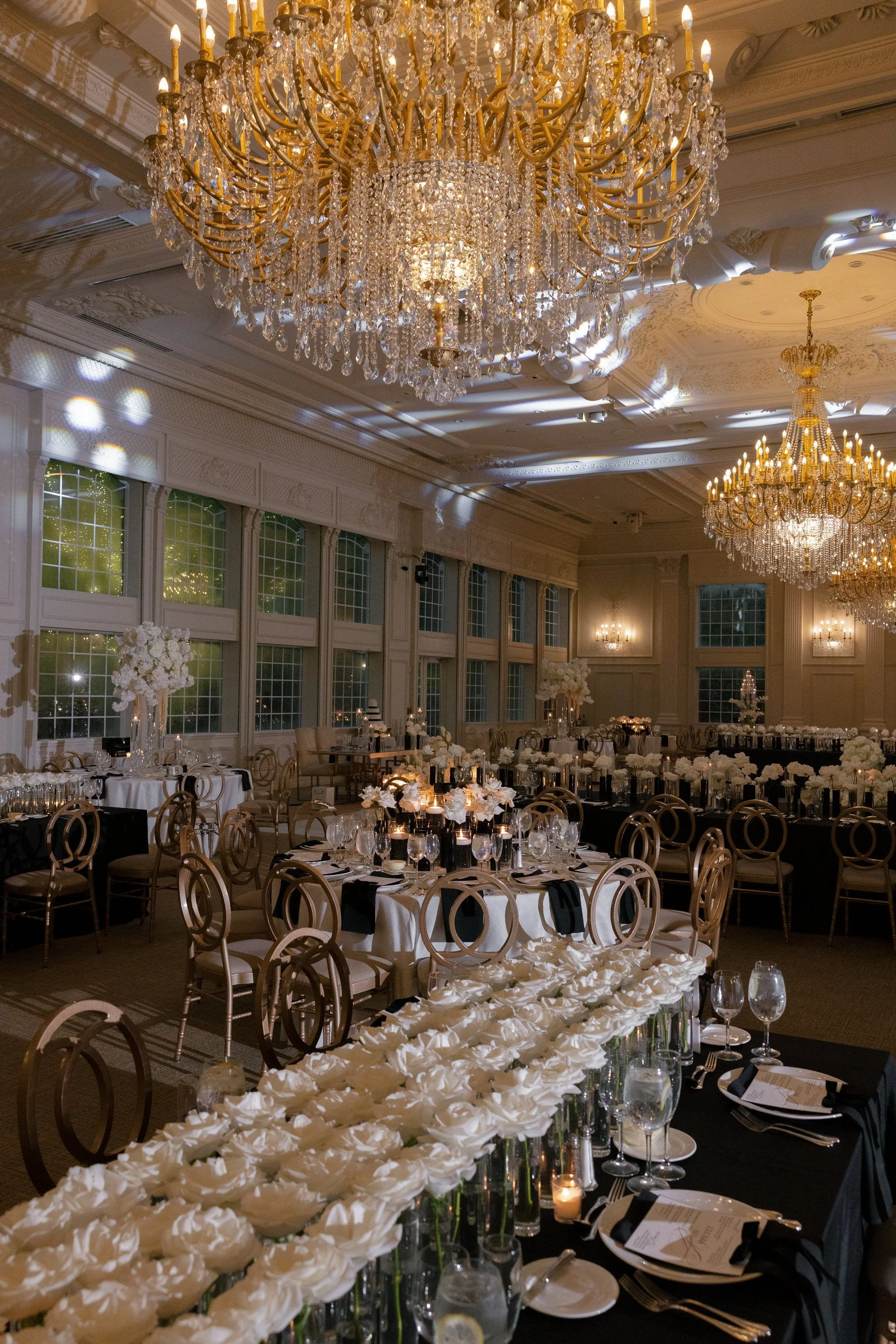 Elegant wedding reception tables with candlelight, white florals and gold details