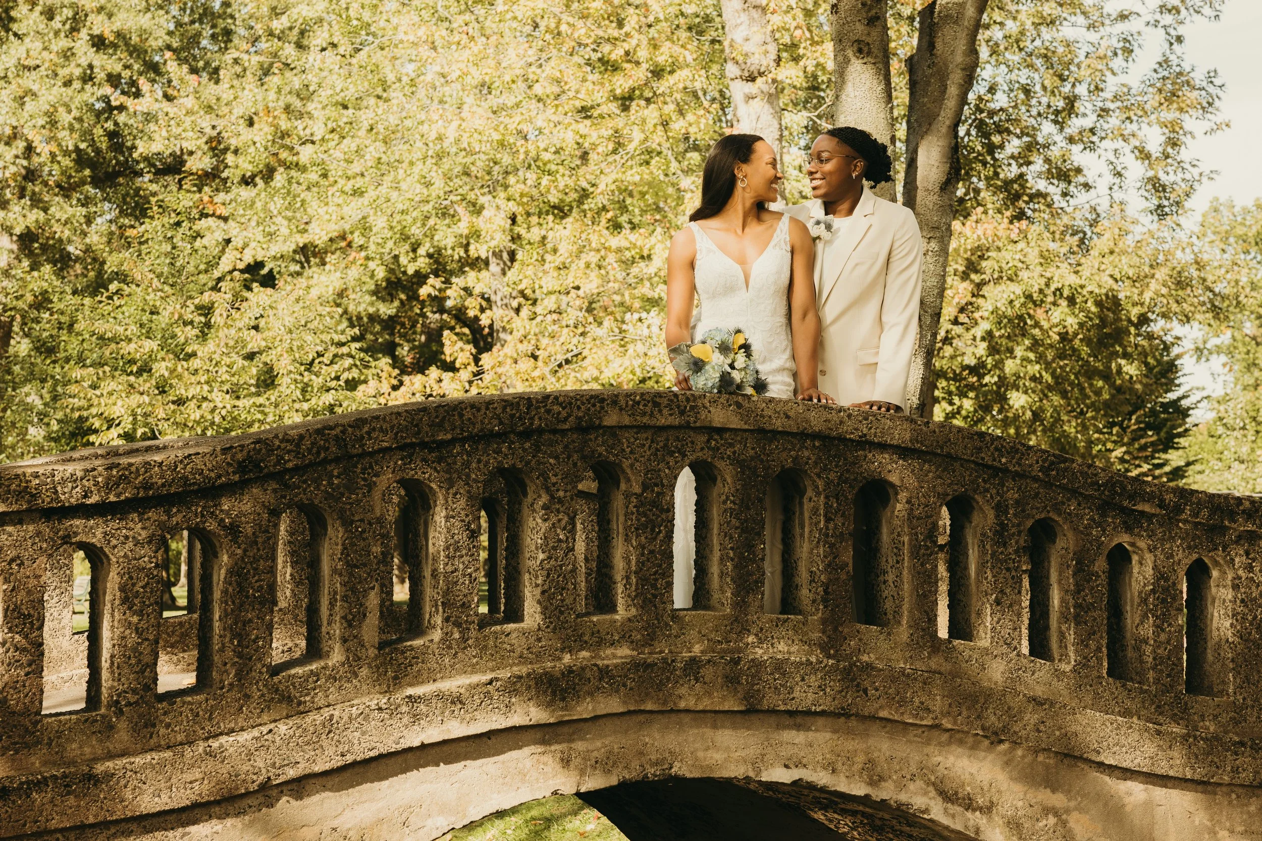 Jaide and Amiaya smile at each other while posing together on a stone bridge at Mindowaskin Park in Westfield, NJ.