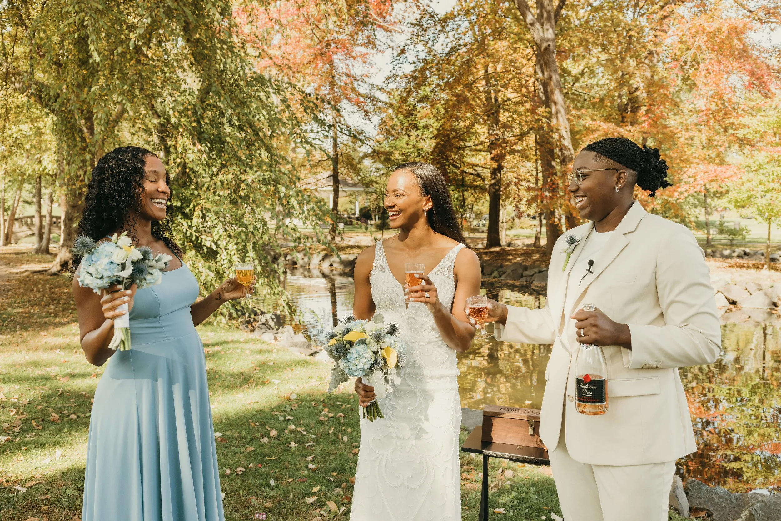 Jaide and Amiaya share a celebratory wine toast with a friend during their fall wedding ceremony at Mindowaskin Park in Westfield, NJ.