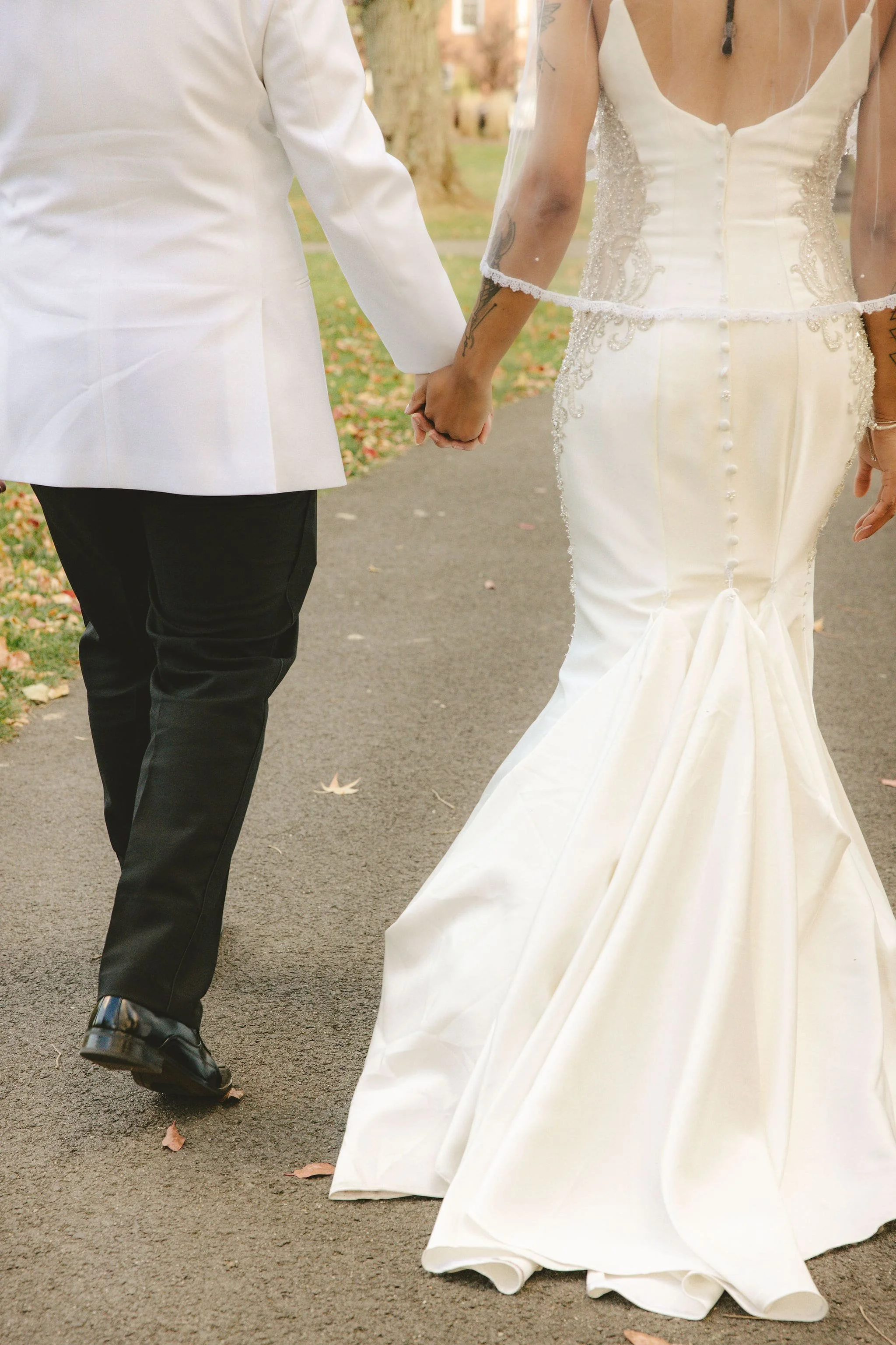 Close-up of two brides holding hands while walking together after their elopement ceremony in Mercer County, New Jersey