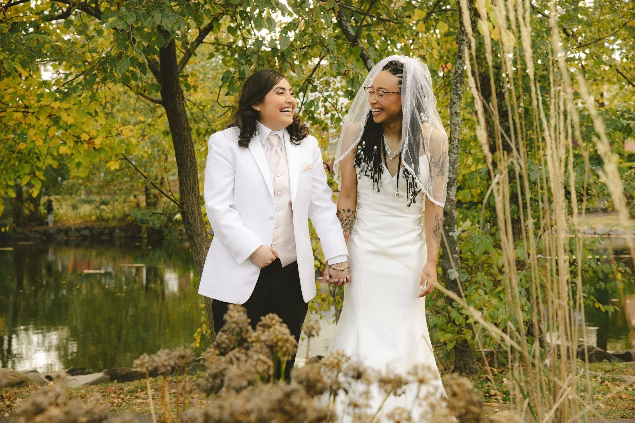 Same-sex couple walking together after an outdoor elopement ceremony in Mercer County, New Jersey