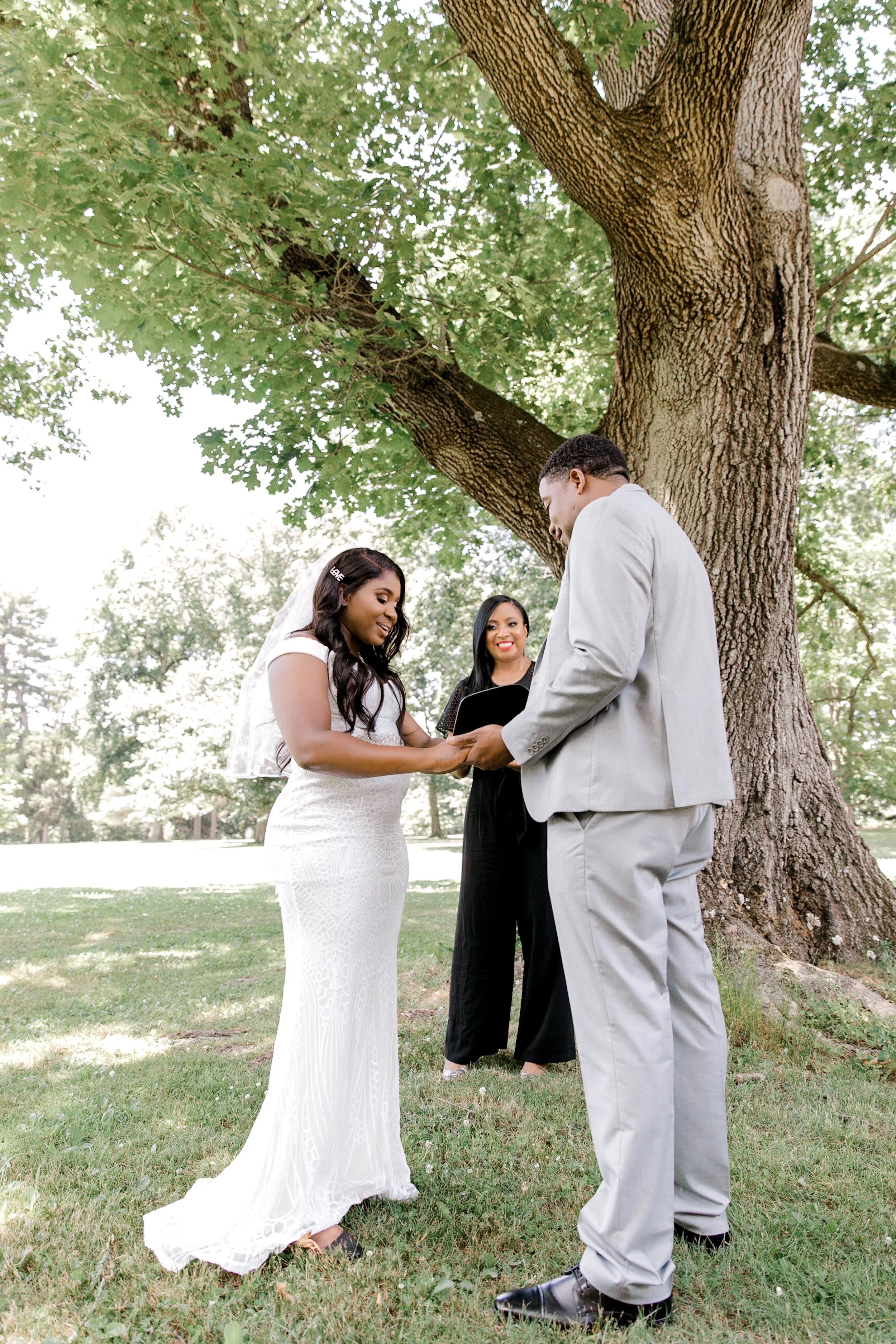 Couple exchanging vows during an intimate outdoor elopement ceremony beneath a tree in Morris County, New Jersey.
