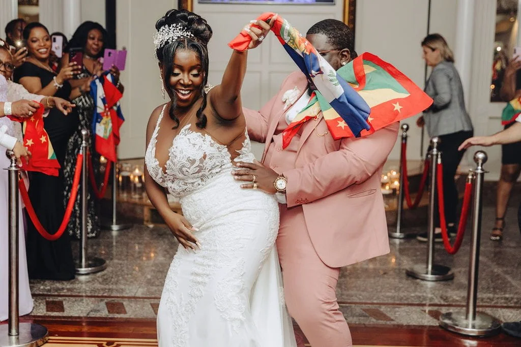 Kristie and Gillon celebrate with Haitian and Grenadian flags during their multicultural wedding reception at The Sand Castle in New York.