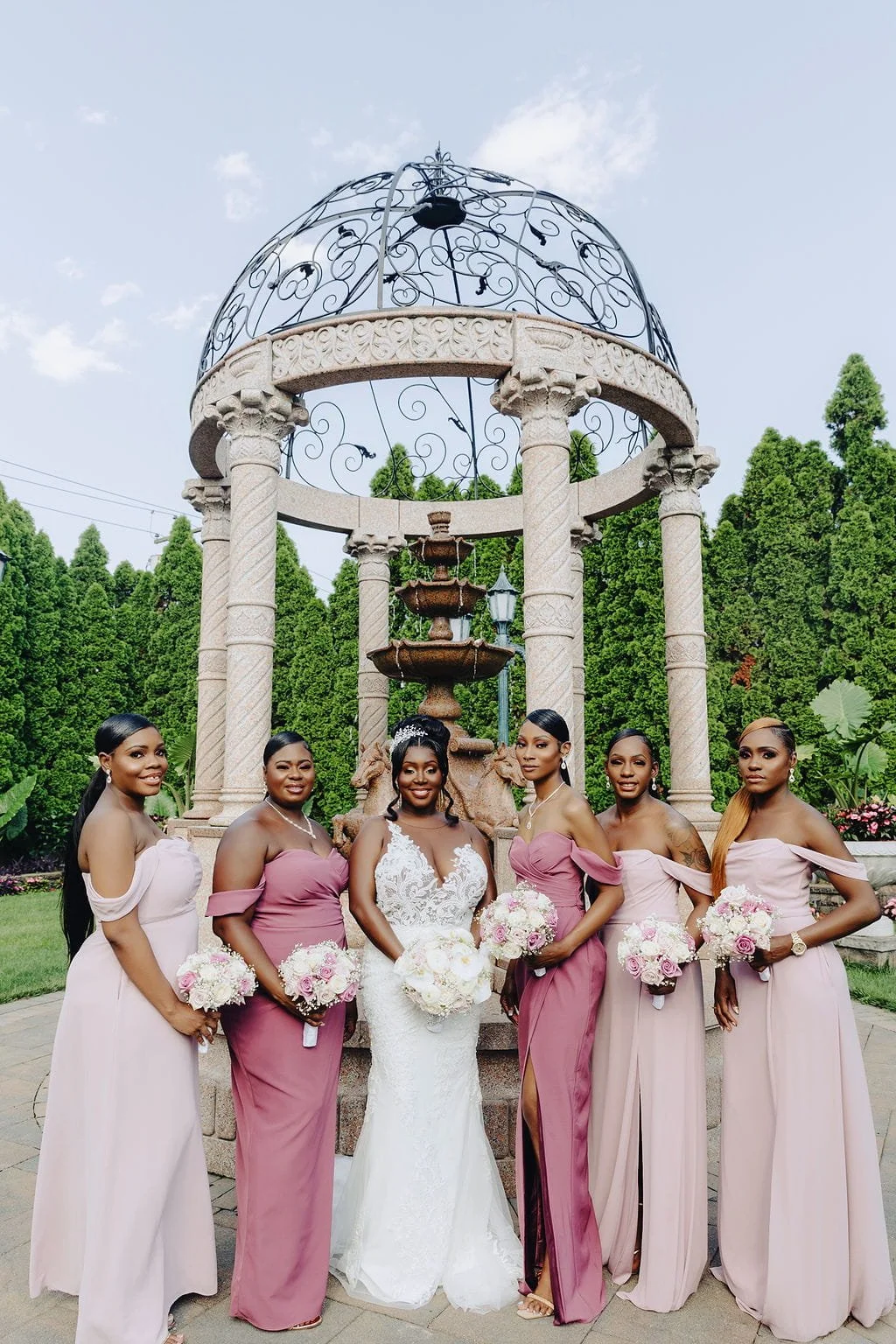 Kristie with her bridesmaids in the gardens at Sand Castle in Franklin Square, NY