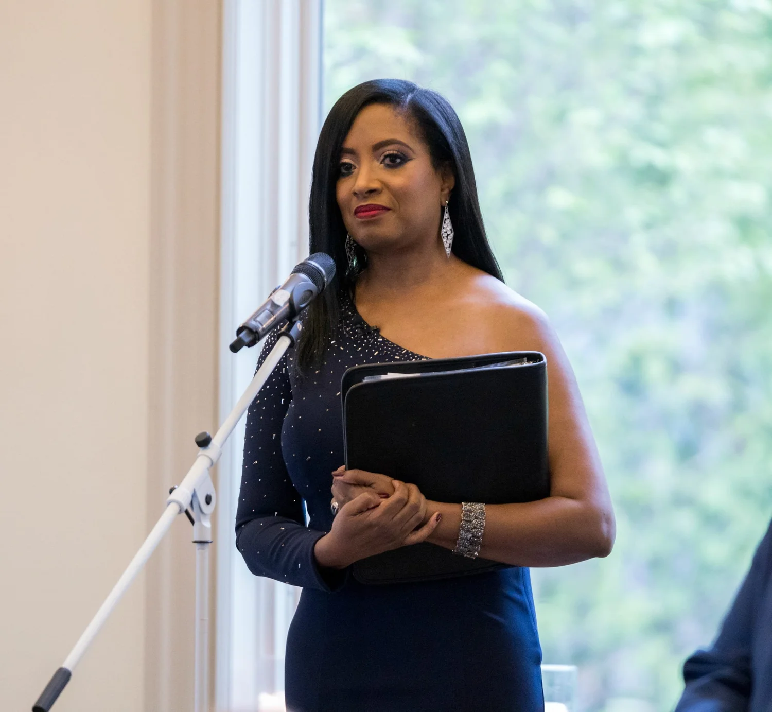 New Jersey wedding officiant Aretha Gaskin in a navy gown at the microphone