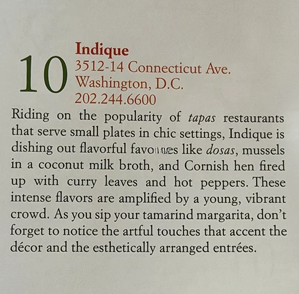 Close-up of a restaurant menu describing Indique, located at 3512-14 Connecticut Ave., Washington, D.C., with phone number 202.244.6600. The menu text discusses tapas, dosas, mussels in coconut milk broth, Cornish hen, and mentions vibrant flavors and decor.