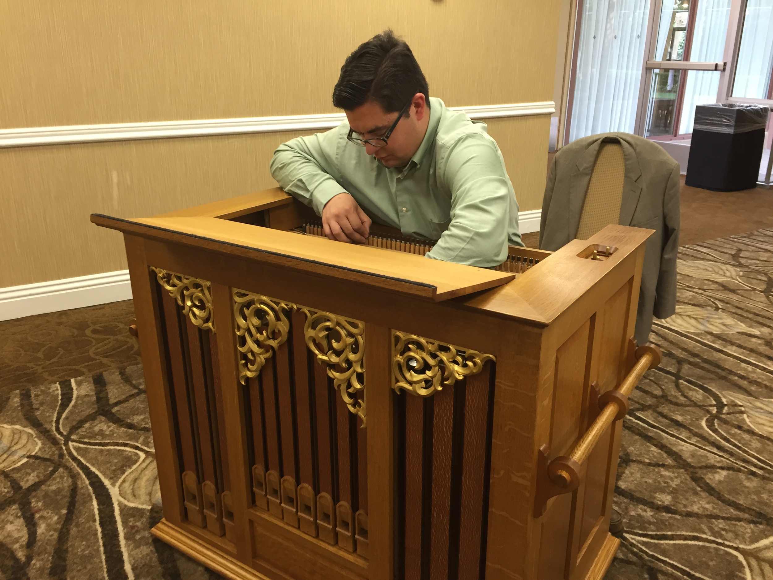 General Manager Nathaniel A. Riggle tunes the Bond Baroque positive. The 8' flute showcased in the instrument's facade is crafted of a naturally patterned wood called lacewood.