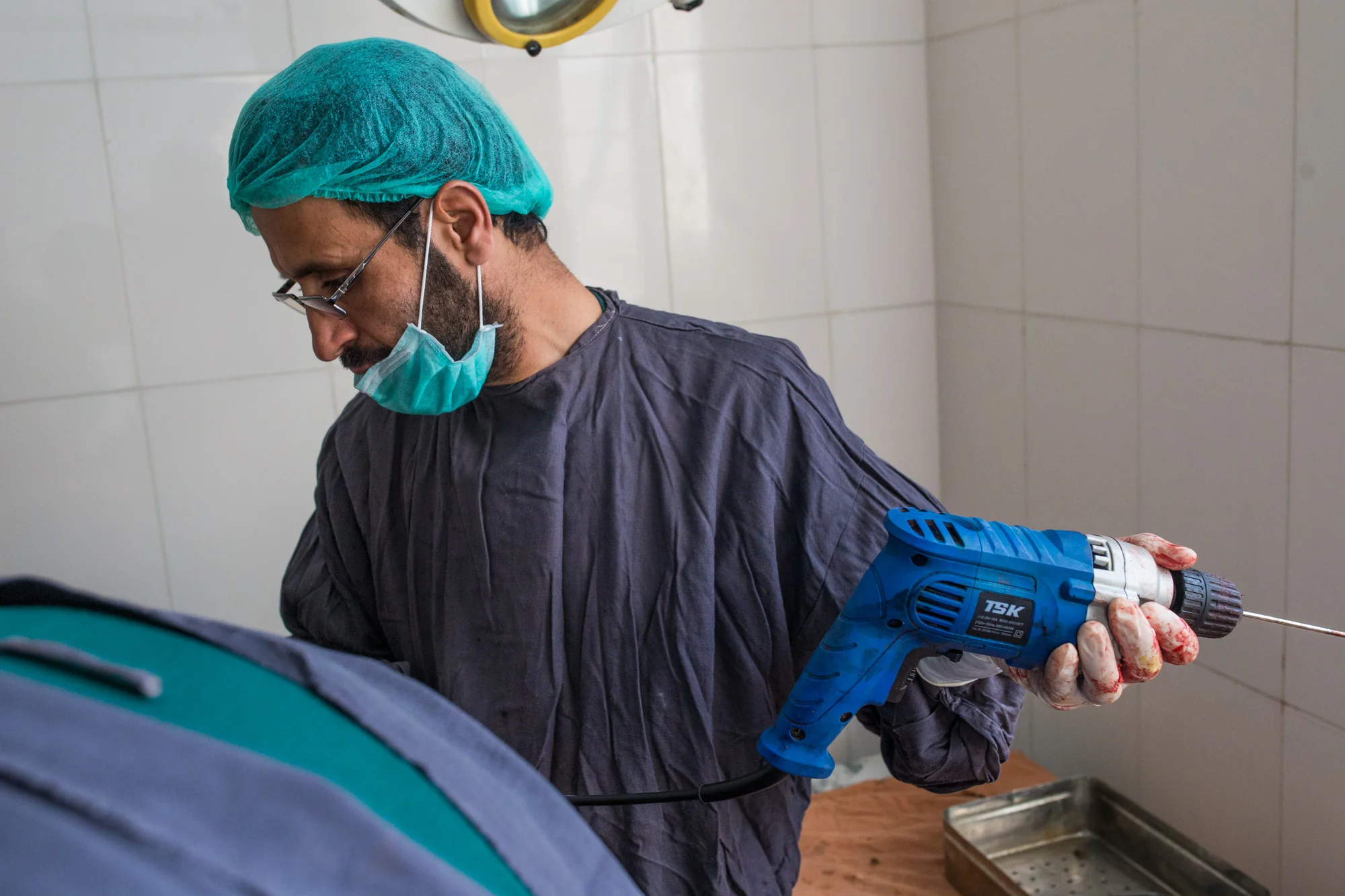 Performing surgery with an electric carpentry drill, due to lack of hospital resources. Wazir Akbar Khan Hospital, Kabul. 2017.