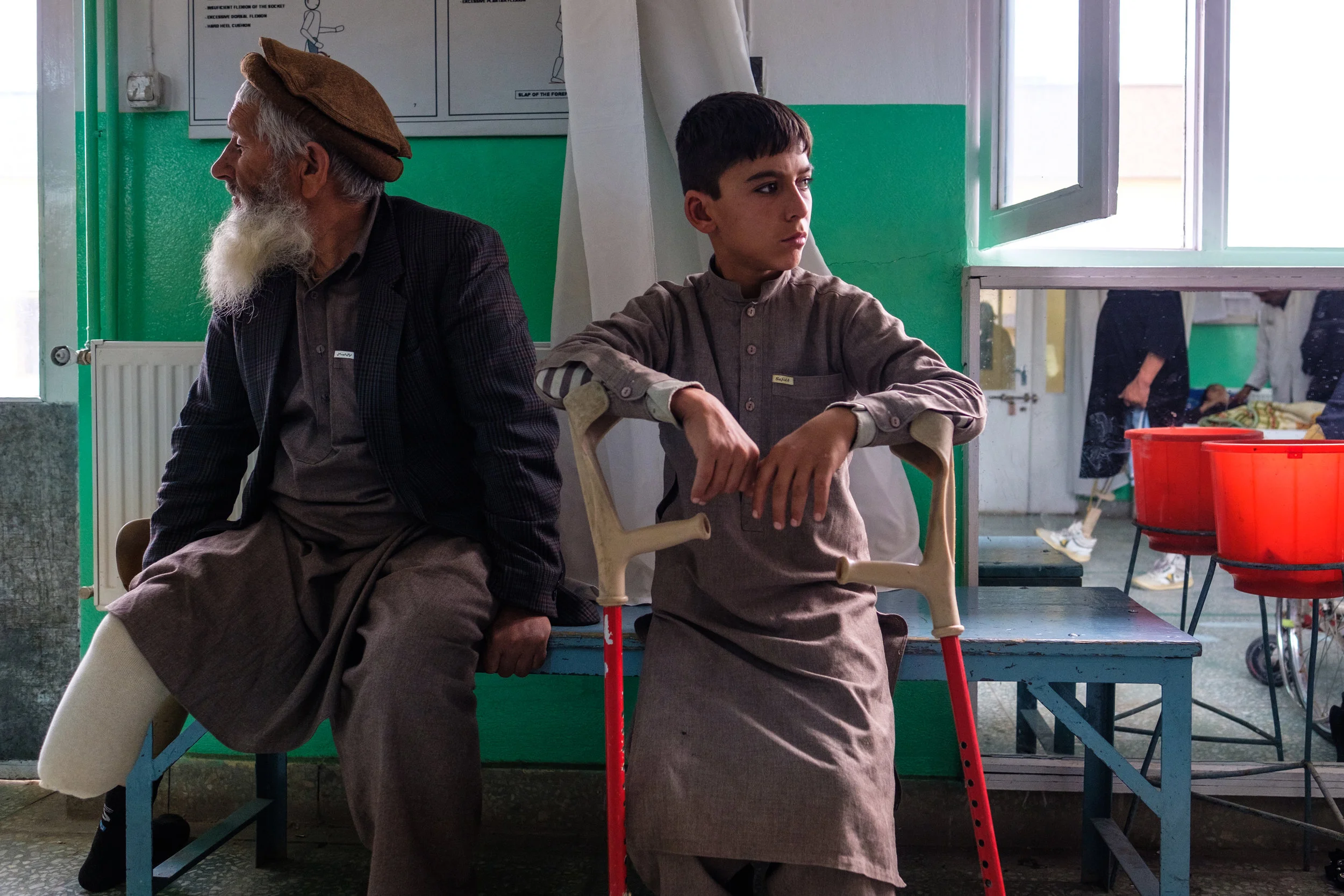 Two generations of land-mine victims waiting to be fitted for prosthetics at the ICRC clinic in Kabul. 2018.