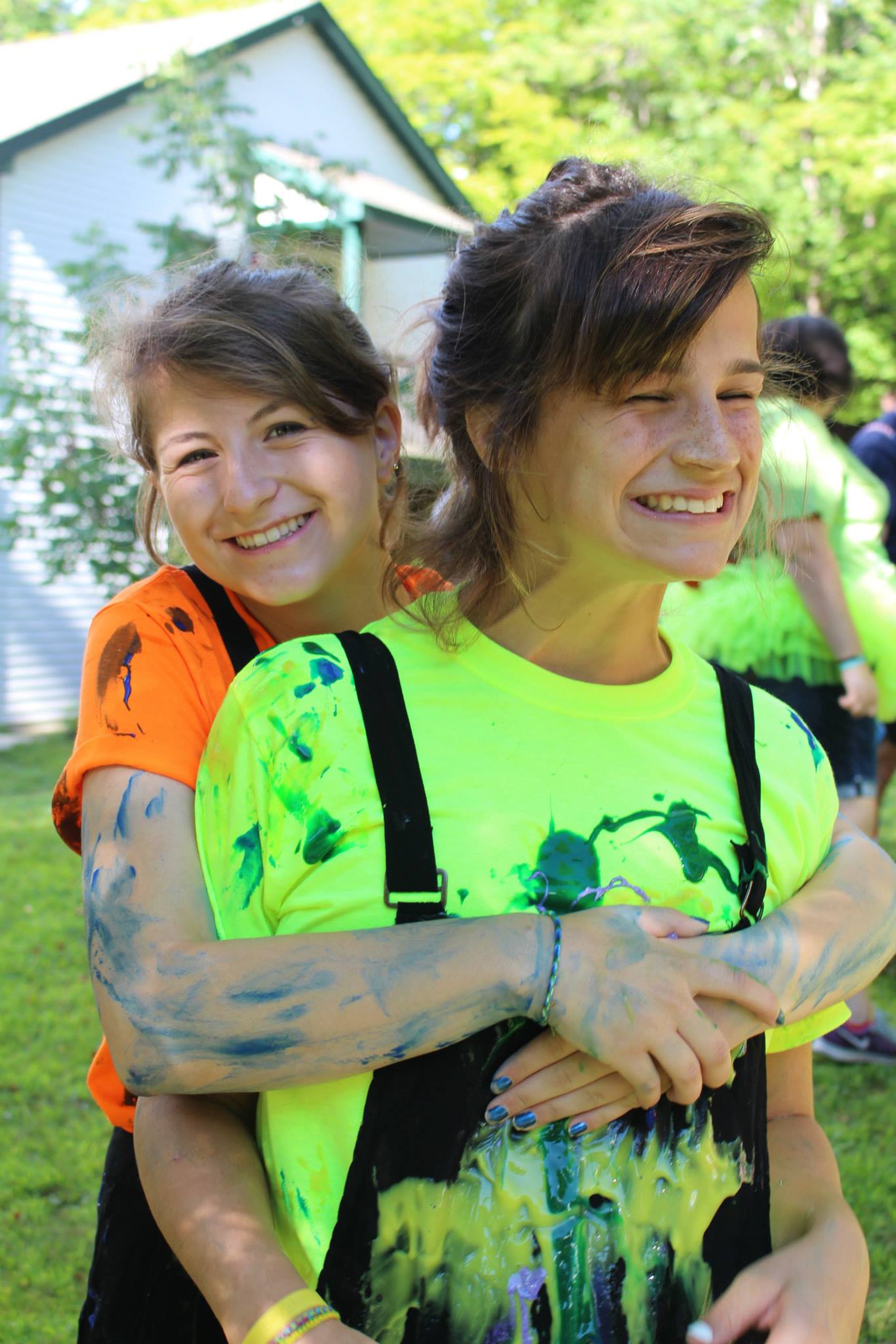 Coral (left) with camper Ellen, smiling after allowing the other campers to decorate their costumes with paint-filled balloons