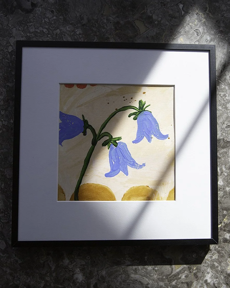 An original acrylic framed painting by Sonja Dahlgren of three expressive bluebells on a yellow ochre background
