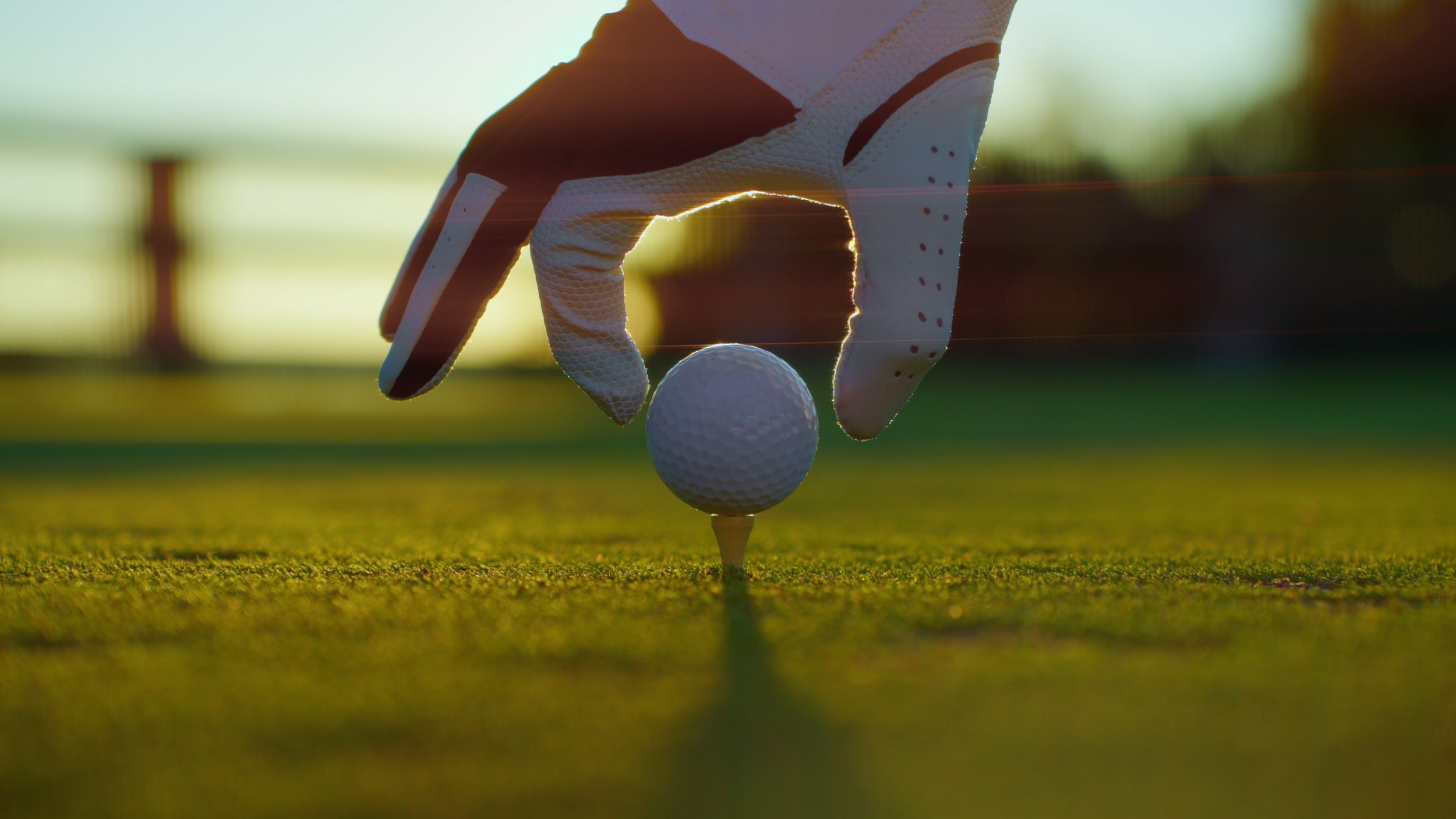 golfer-placing-golf-ball-on-the-tee-at-golf-course-close-up-people-sport-leisure-activ-SBI-350683638.jpg
