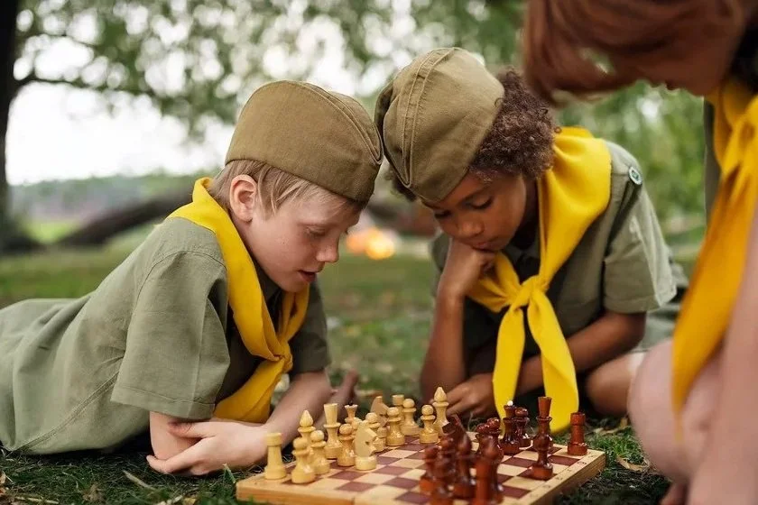 Children playing chess during a group chess lesson