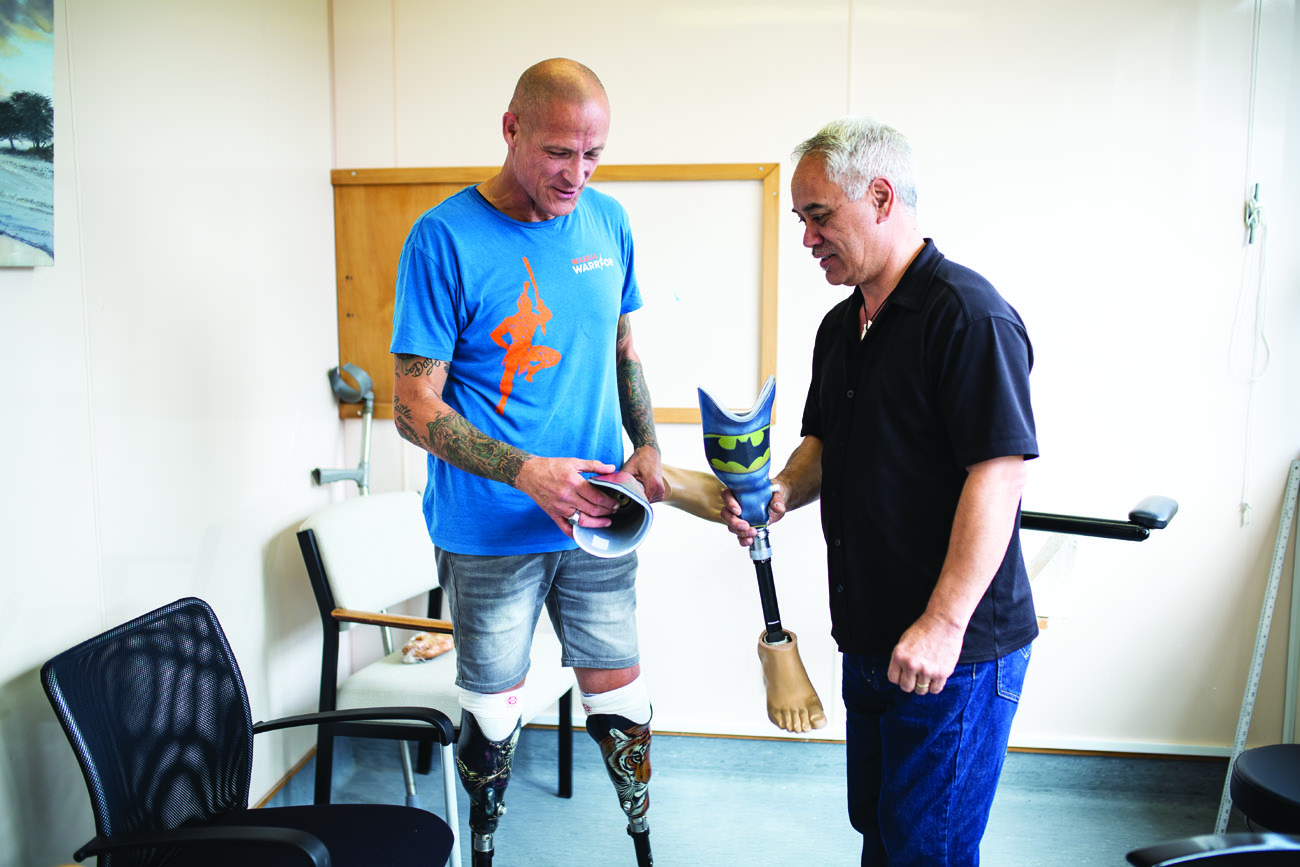 Ken presents new swimming legs to Shane at NZALS in Wellington. Shane wanted superhero designs for his grandchildren.