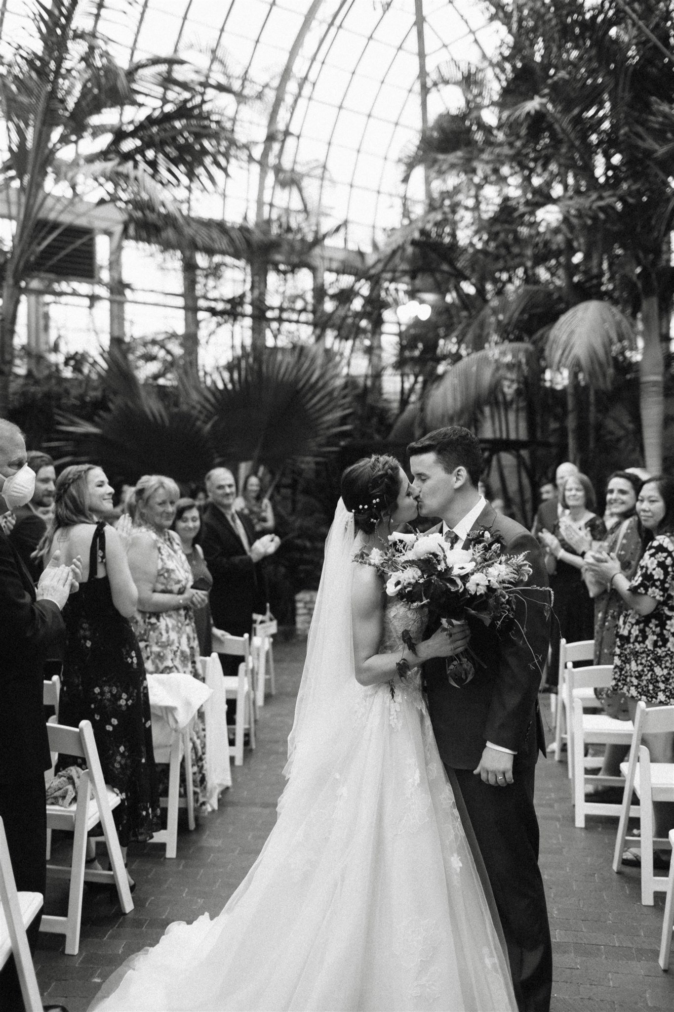 Bride and groom kiss Wedding recessional in Greenhouse
