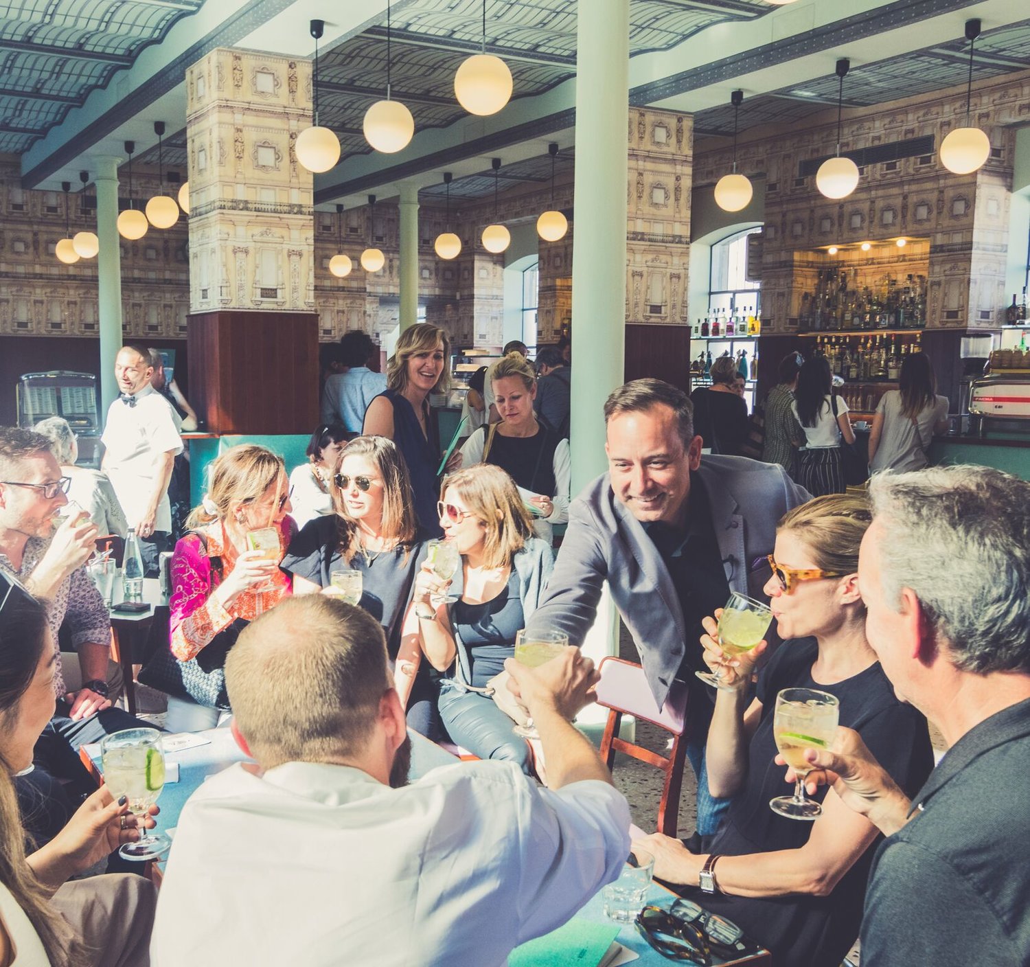 The group enjoys a refreshment at Bar Luce, designed by Wes Anderson, after a tour of the Prada Foundation.