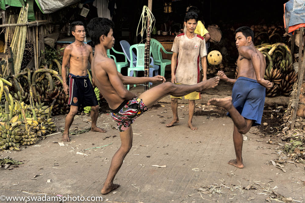 Young men take a break after unloading bananas to play chinlone, a popular Myanmar game similar to hackysac.