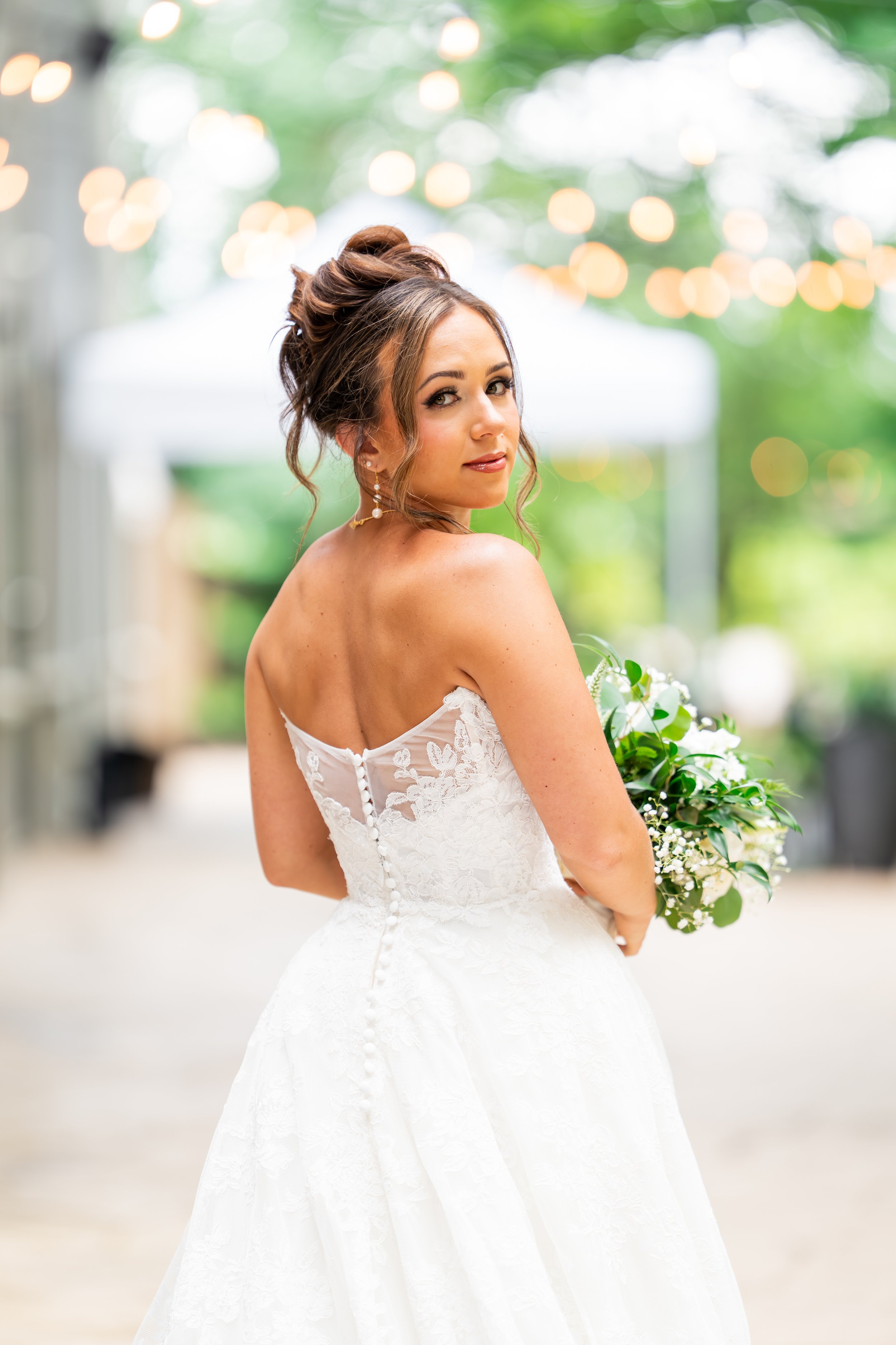 Wedding invitation surrounded by flowers, with wedding bands and a heart-shaped wooden box inscribed with the wedding date.
