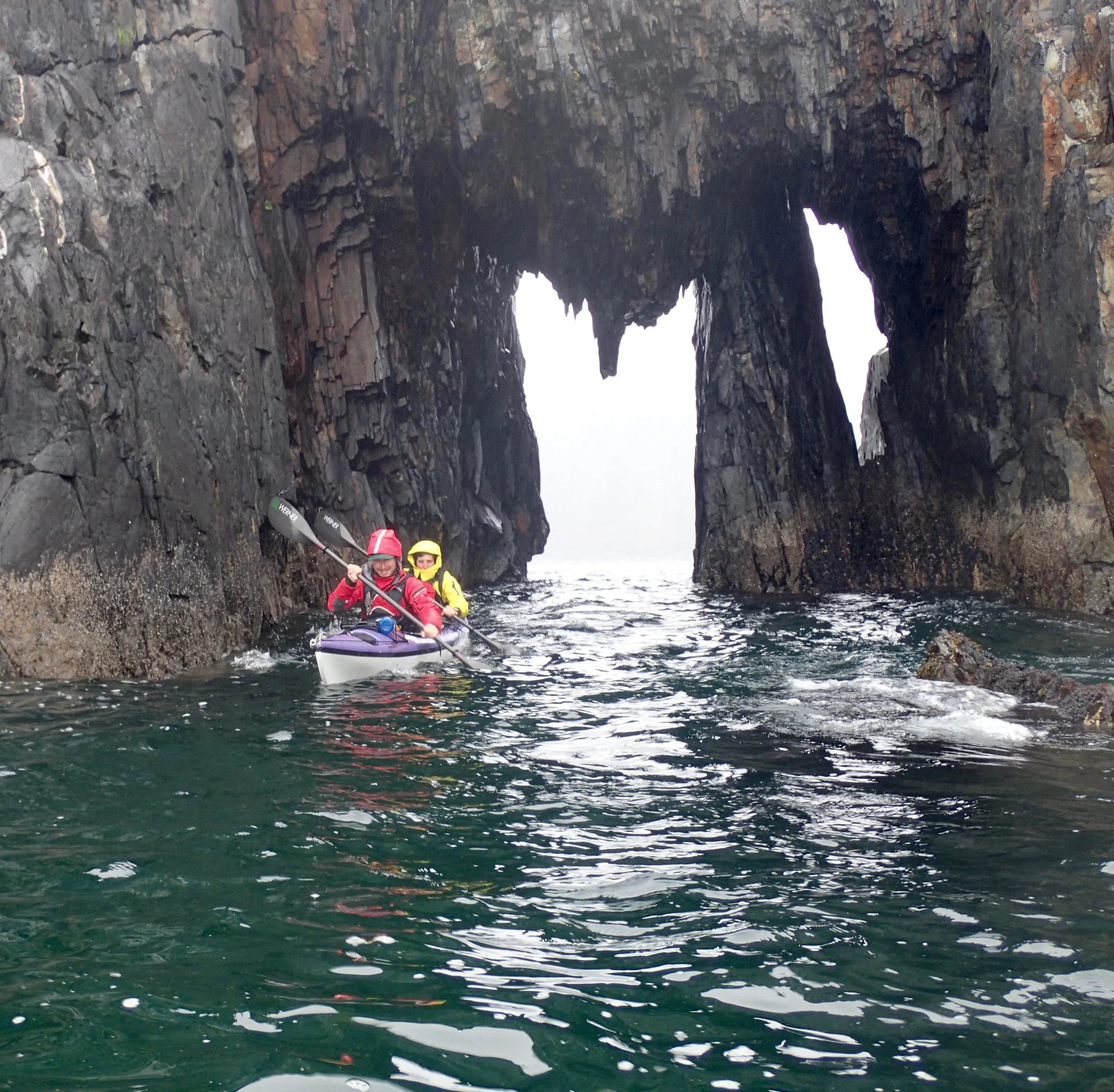 Guides Andrew and Kelly (K2) paddling through the sea arch at Holgate Head at the end of the day.