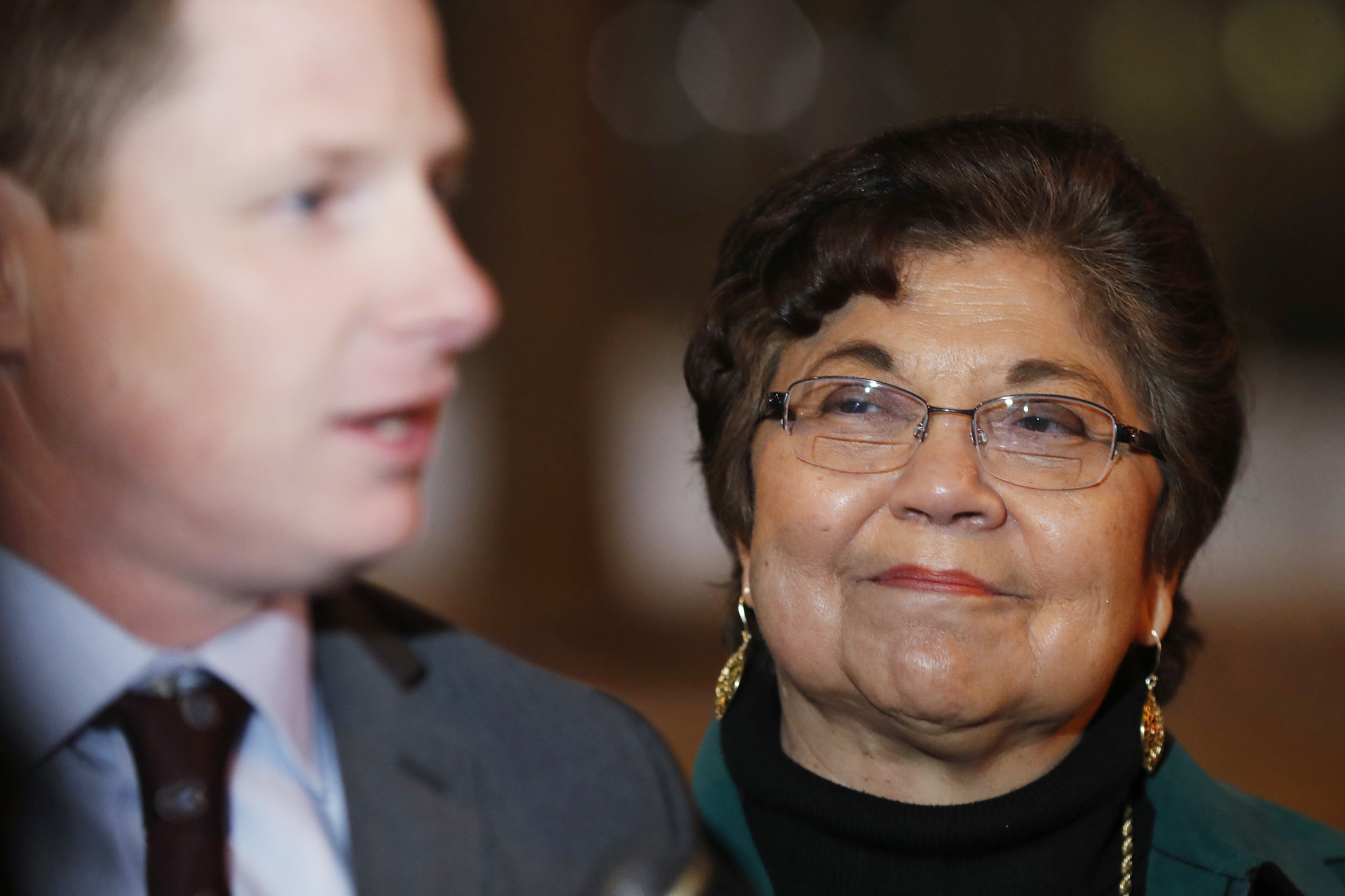 "Faithless" Elector, Polly Baca, watching her attorney address the press.