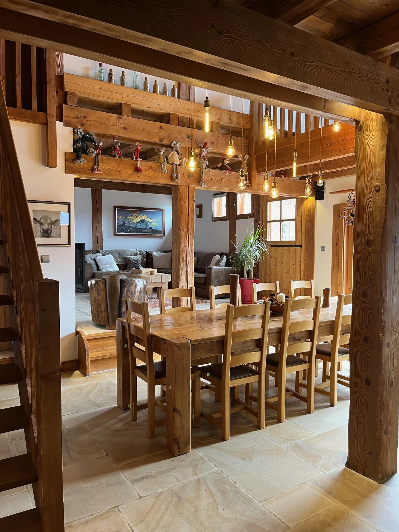 Open-plan dining and living area at Chalet Le Pery with wooden dining table and cosy lounge