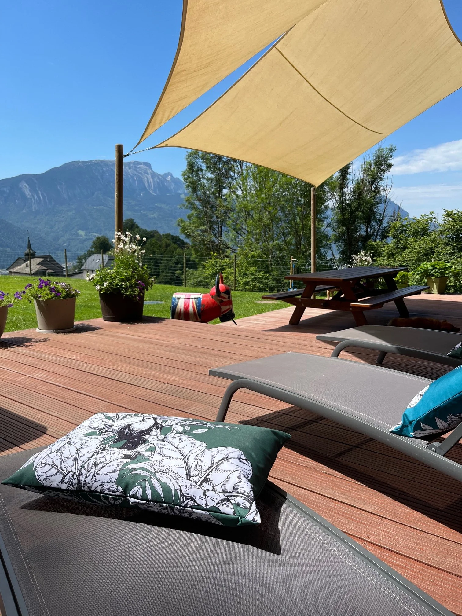 Sunny terrace at Chalet Le Pery with sun loungers, outdoor seating and mountain views