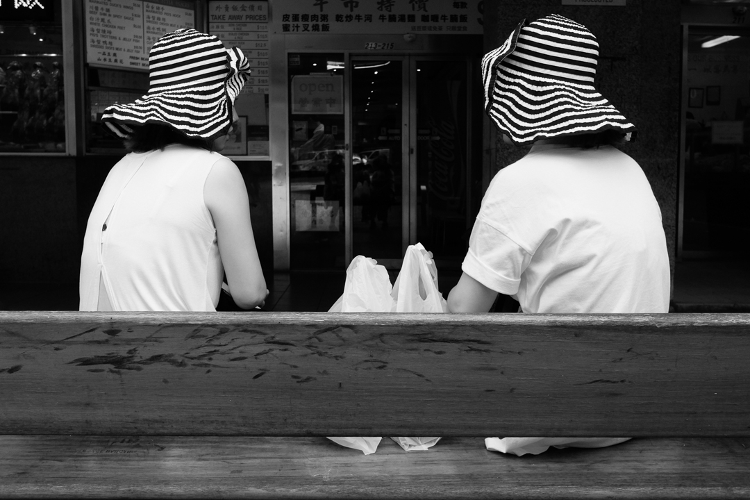 Street portrait of two sisters wearing a striped hat in Haymarket, Sydney| 28mm lens | 2018