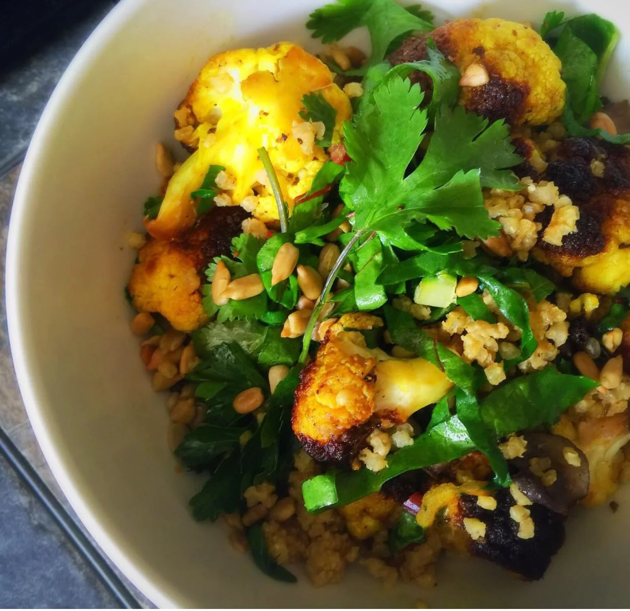 Turmeric Spiced Caulflower with Millet and Mushrooms. Topped with Sunglower Seeds, Rainbow Chard and Cilantro.