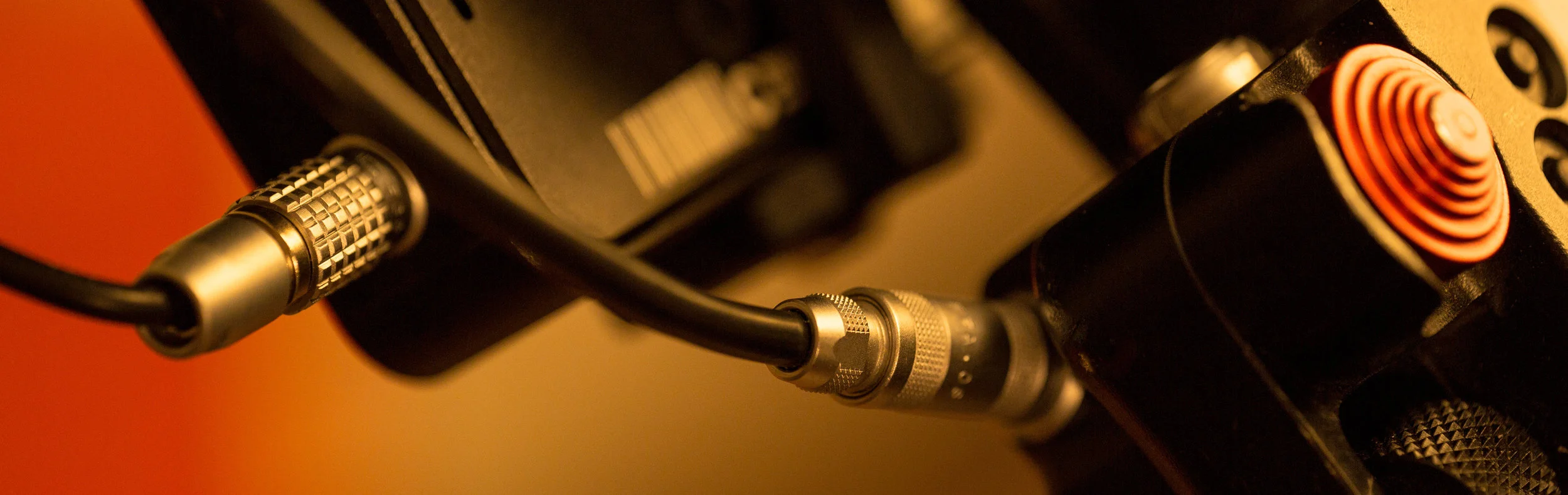 The included Power Y-Cable connects to the Base Unit via a Lemo plug (right) and feeds power from the L-series battery to monitor and, in this case, to a Cinegears Ghost-Eye 150M receiver via a 2-pin Lemo (left). If you change to a different monitor/receiver combo, you need only change out the cable.