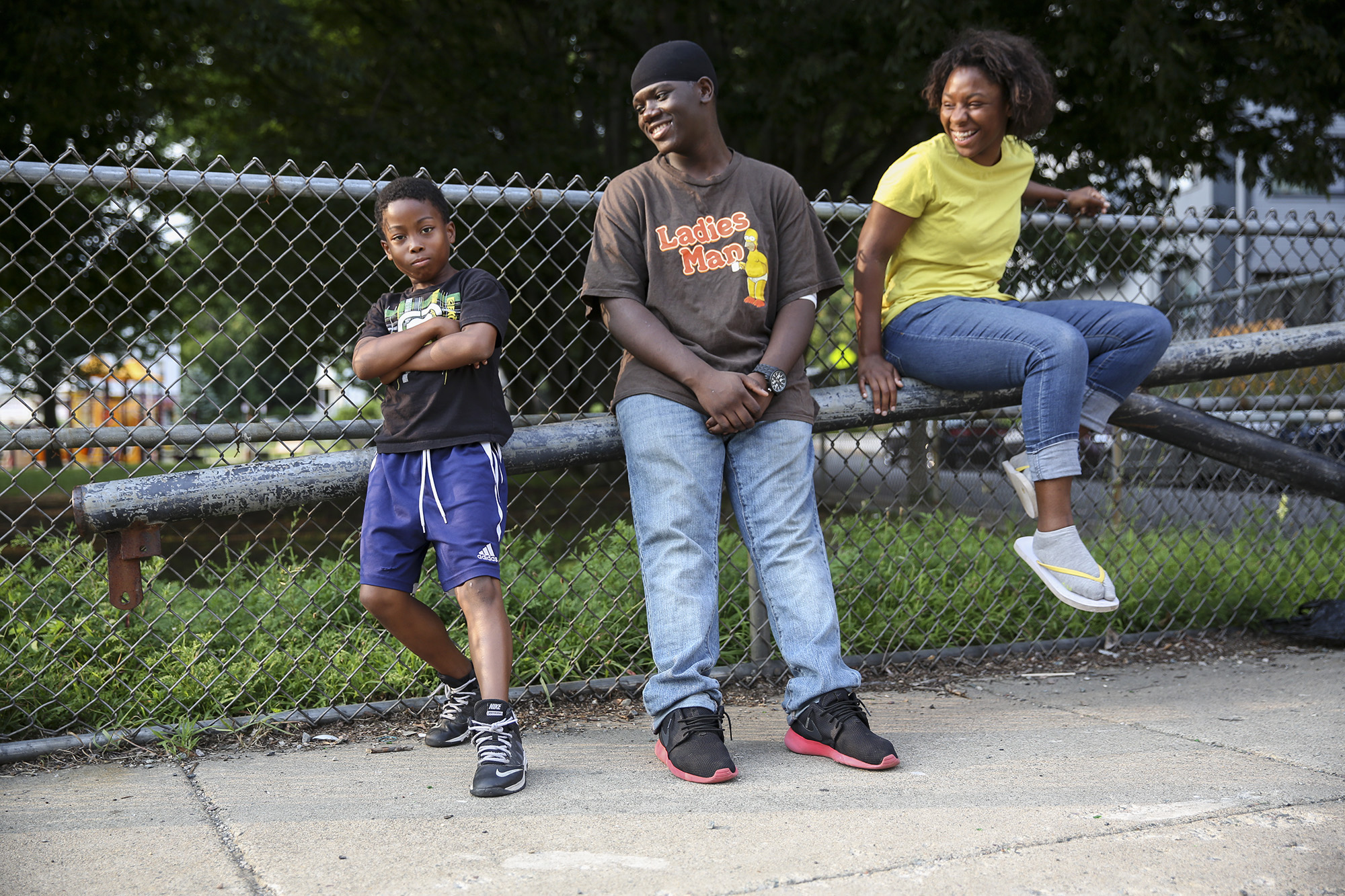 "What's going on here?!" Frankie, a spunky outspoken 11-year-old, says with his arms spread by his side in confusion, looking back and forth from me to his friends as I photograph them. Dmitri James, center, and Racheal Fraylon, laugh as Frankie qui