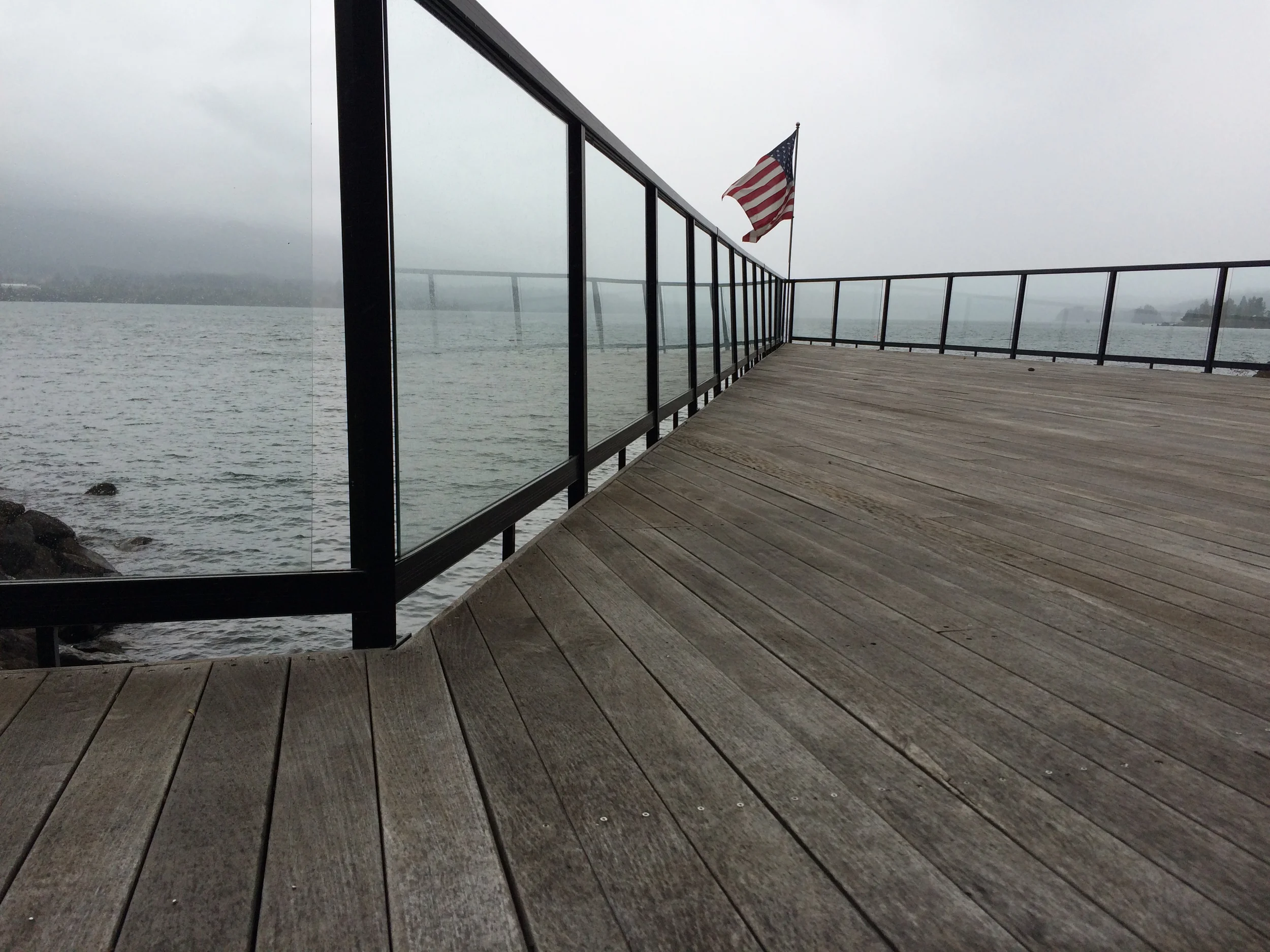 Cleaning glass railing on deck over Columbia River