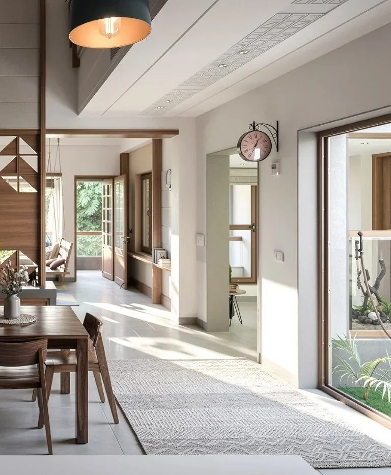 Interior of a modern home featuring a dining area with a wooden table and chairs, a hallway with natural light coming through windows, and a cozy sitting nook visible in the background. The space is decorated with warm wood accents, a large clock on 