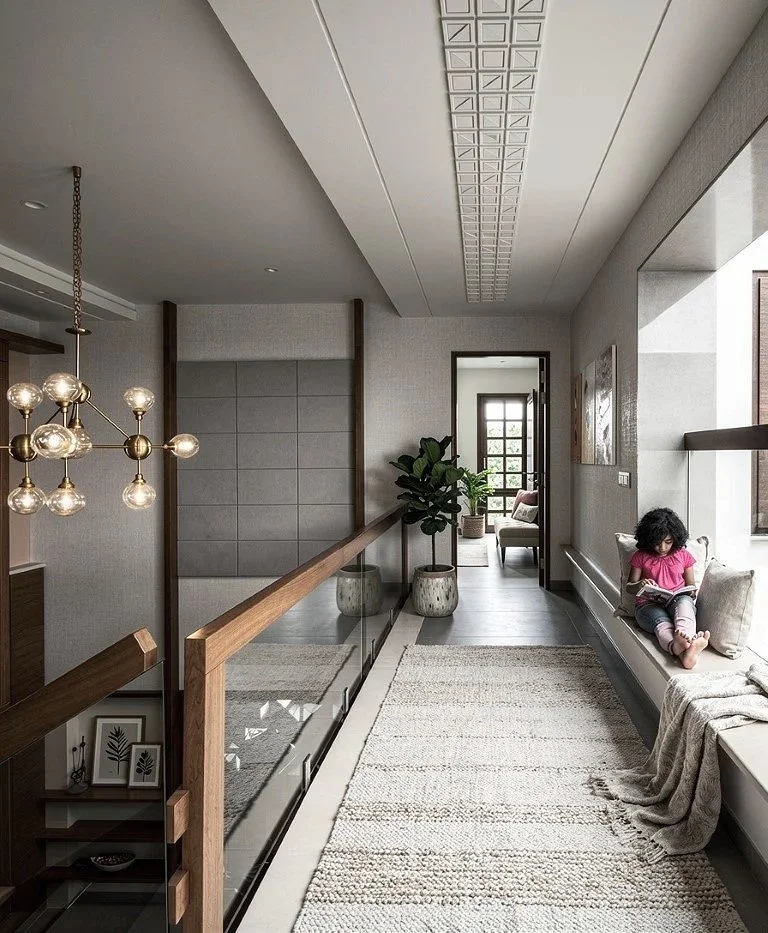 Bright hallway with large window seat, girl sitting and reading, modern decor, potted plant, artwork, and decorative pillows.