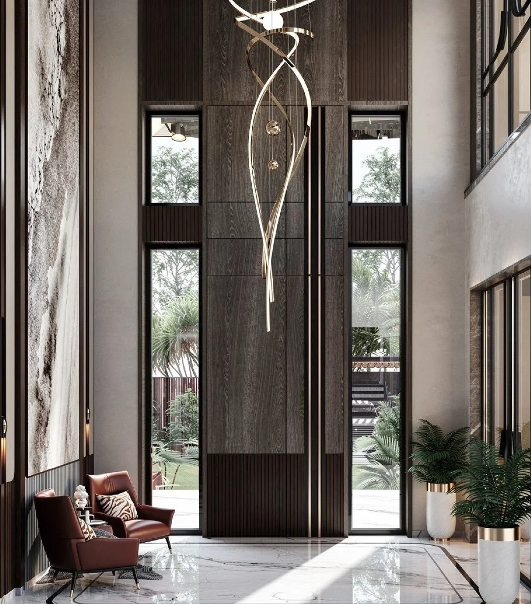 Interior of a modern living space with tall windows, a tall central decorative wall, a contemporary chandelier hanging from the ceiling, potted plants, and stylish chairs.