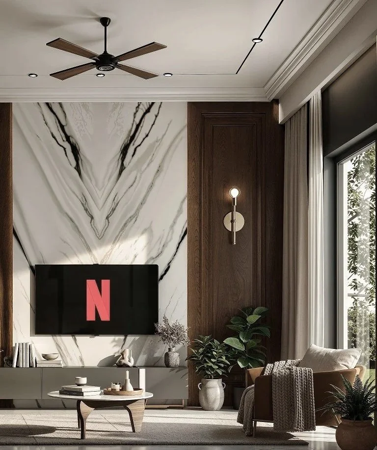 Modern living room with a wall-mounted Netflix TV, a ceiling fan, a wooden panel wall, a large marble accent wall, indoor plants, a seating area with a beige chair, and a large window with curtains.