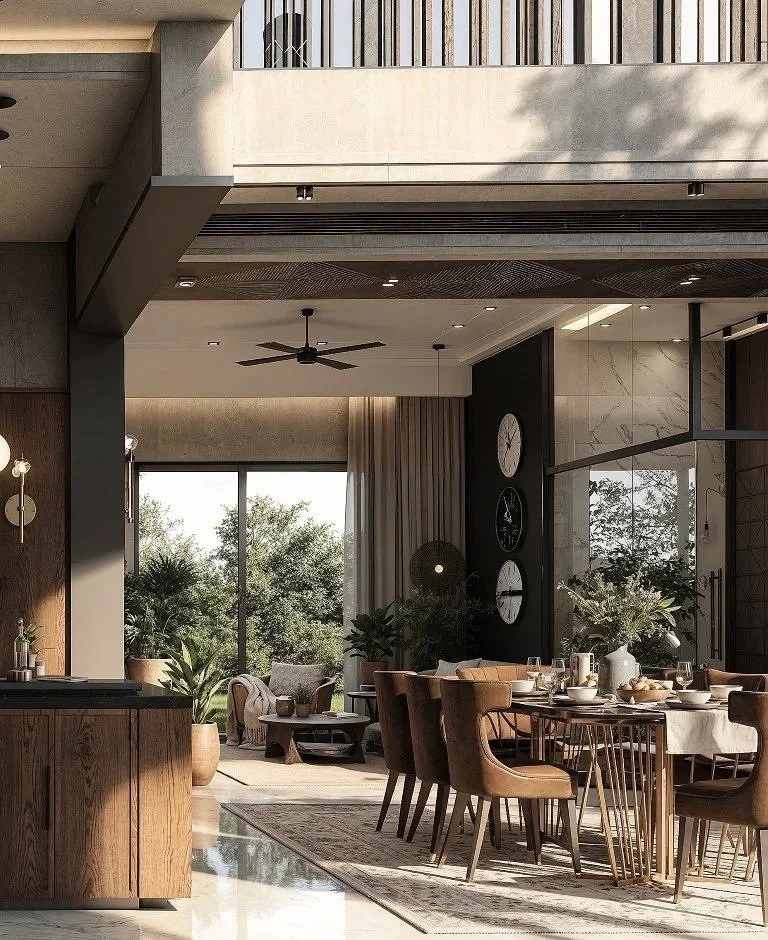 Modern dining room with a large wooden table, six leather chairs, and a decorative wall with clocks. The room has large windows showing trees outside and natural light streaming in.