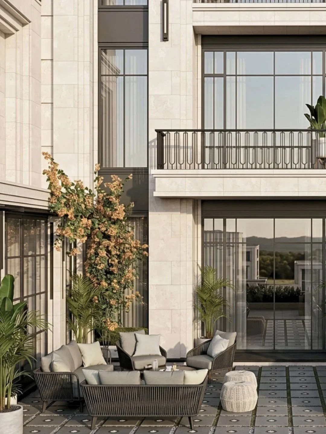 Outdoor patio area with modern seating, potted plants, and a multi-level building with large glass windows and a balcony.