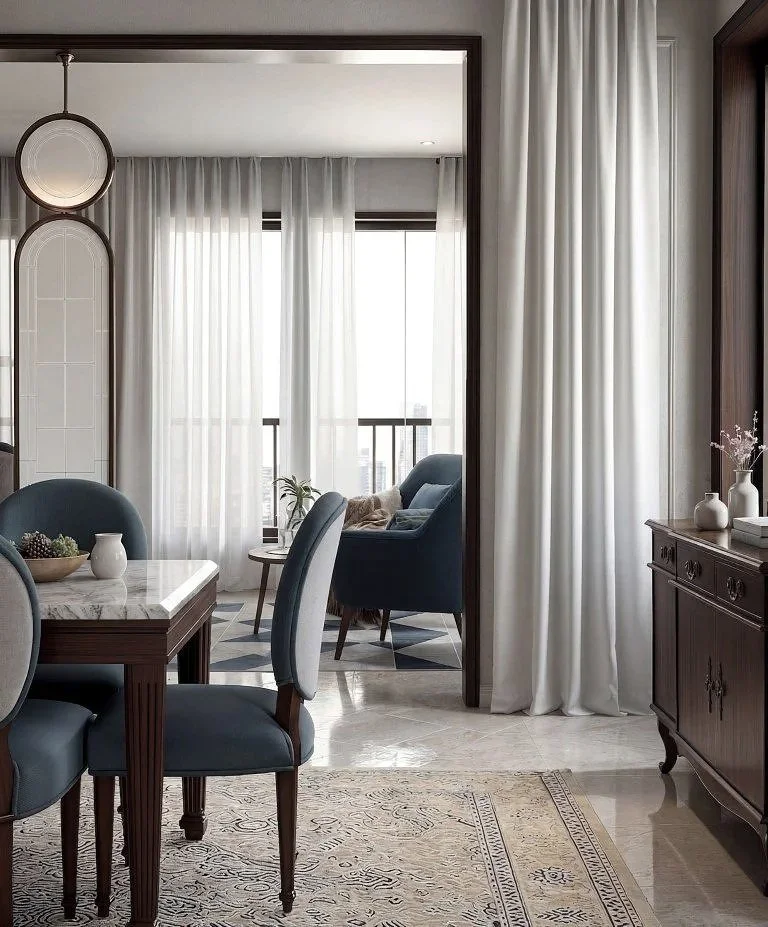 A modern decorative room divider made of glass and copper, with an elegant geometric design, partially obscuring a sitting area with a light-colored sofa, small side tables, a potted plant, and large windows with sheer curtains.