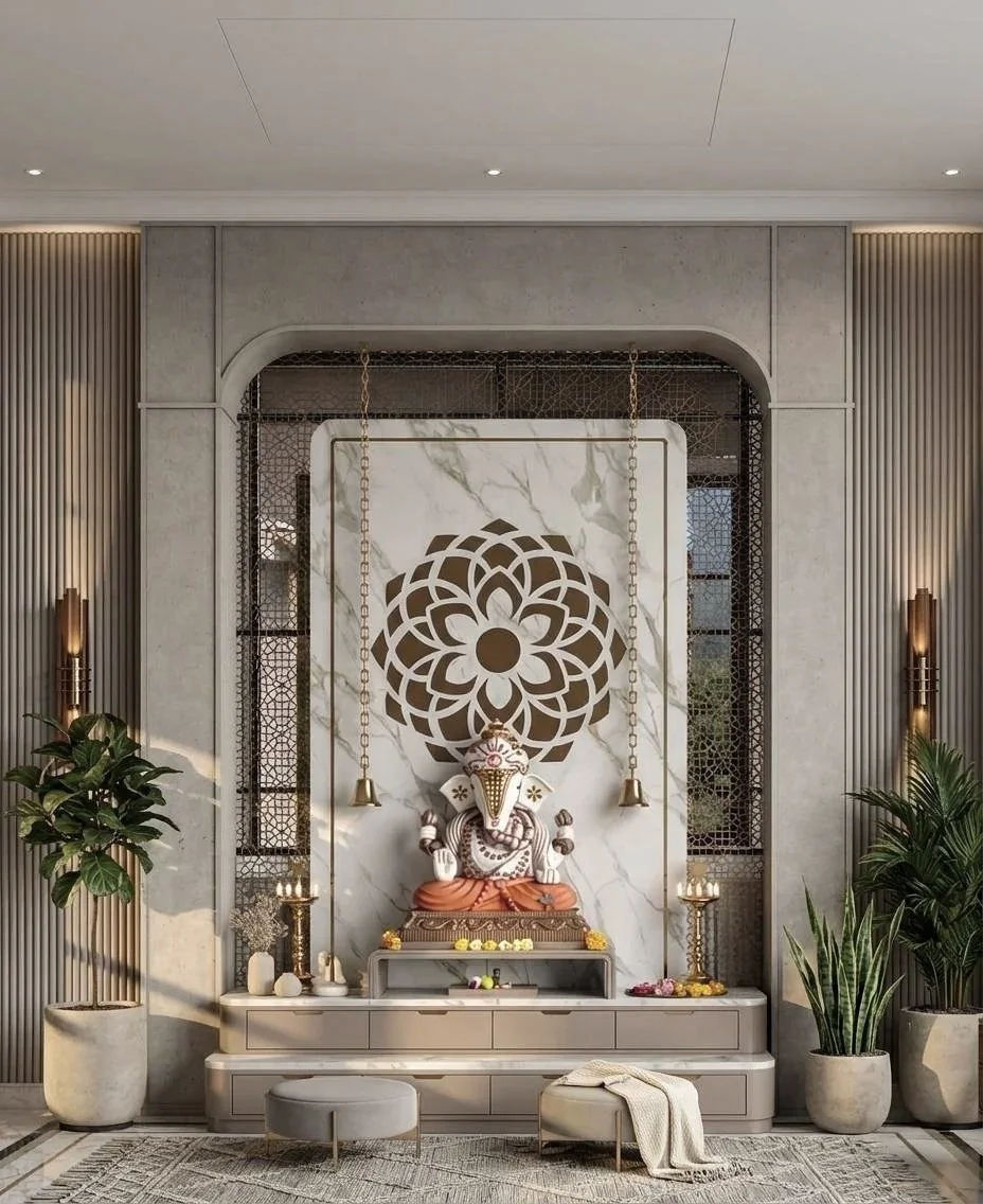 An elegant prayer or meditation space with a white and gold aesthetic. Features a white elephant sculpture adorned with gold, flanked by candles and decorative fixtures, with a large intricate floral design on the wall behind.
