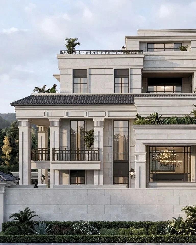 Luxury multi-story mansion with cream-colored stone facade, large windows, and multiple balconies with black railings, surrounded by well-manicured plants and trees.